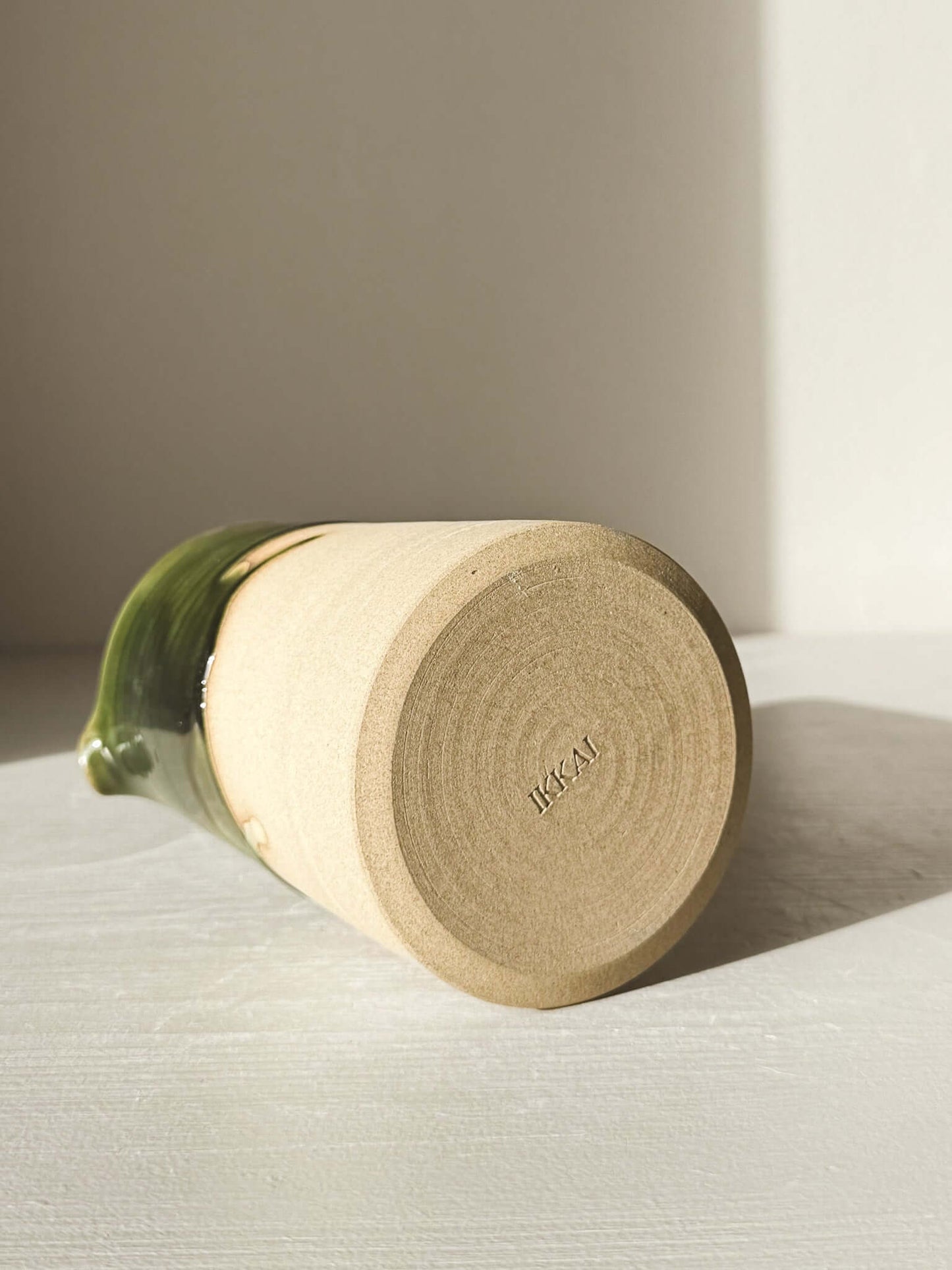 Medium Vase/Jug – Mori #01 showcasing raw toffee clay base with glossy green glaze around upper half on a sunlit surface.