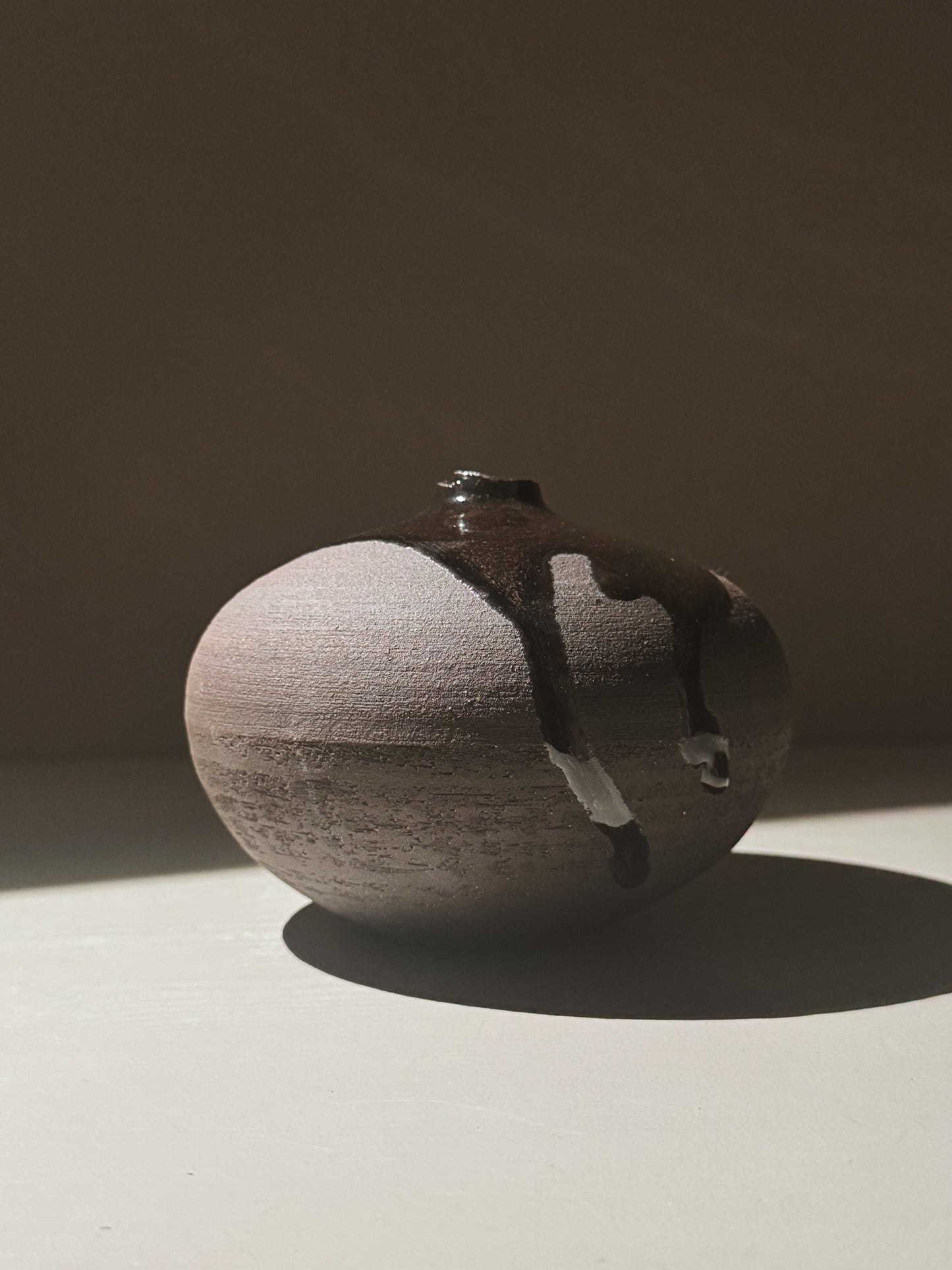 Orb Vase – Kuro Black #01 showcasing unique glaze movement and organic patterns in a sculptural form.