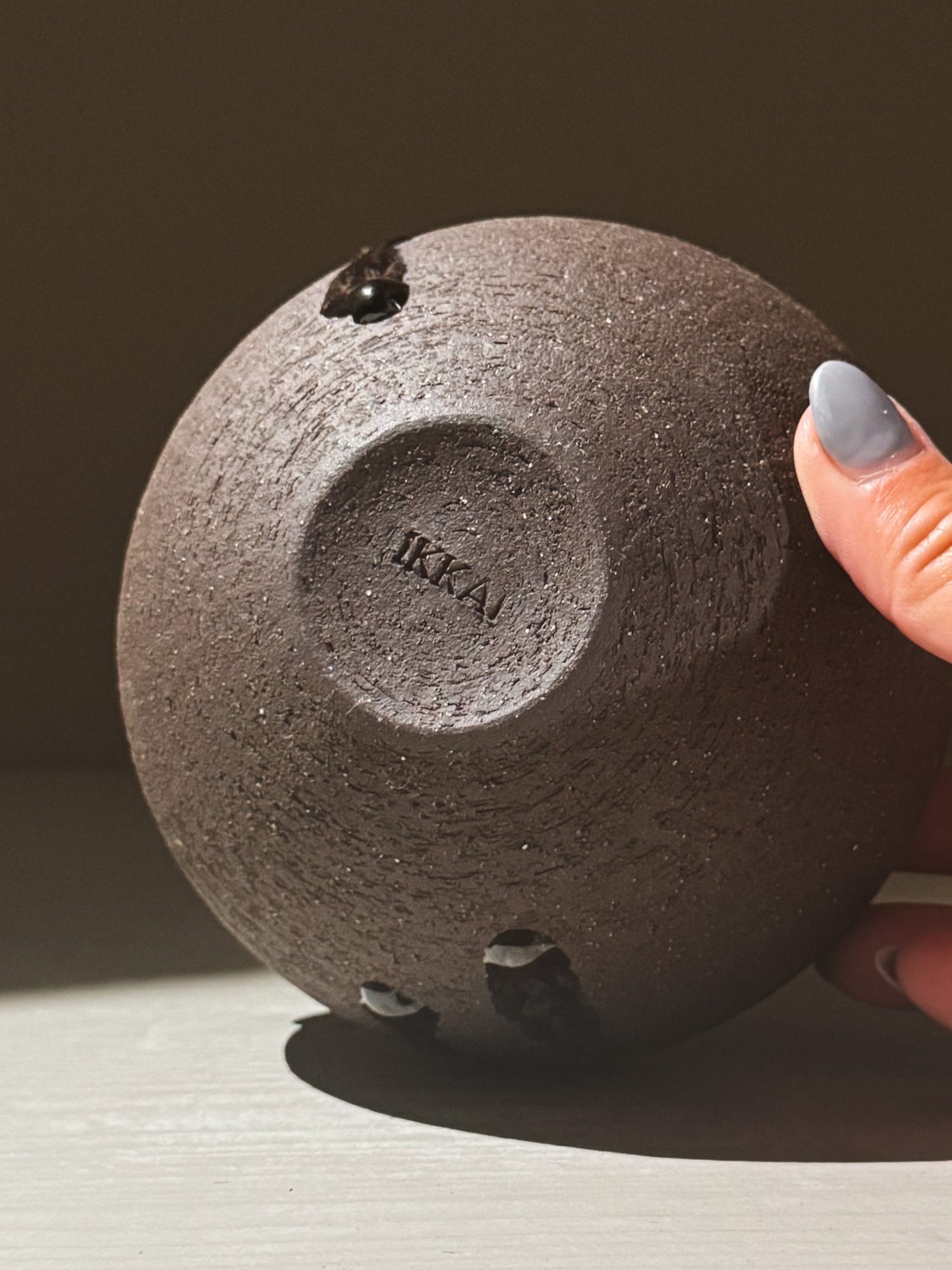 Close-up of the bottom of an Orb Vase – Kuro Black #02 showcasing its unique texture and IKKA imprint.