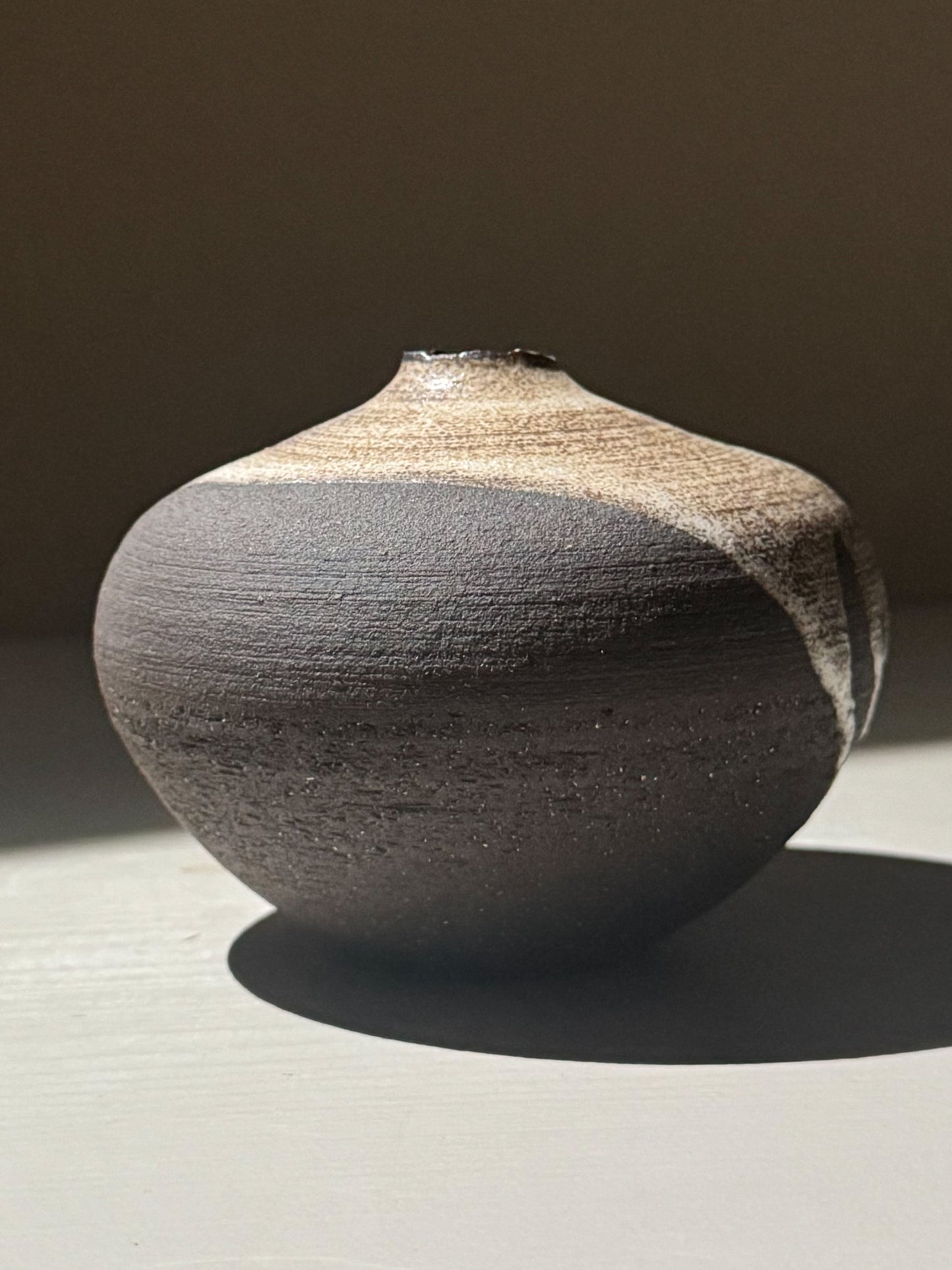 Orb Vase – Matt Clear, a unique rounded ceramic vase with natural glaze patterns and a sculptural presence.