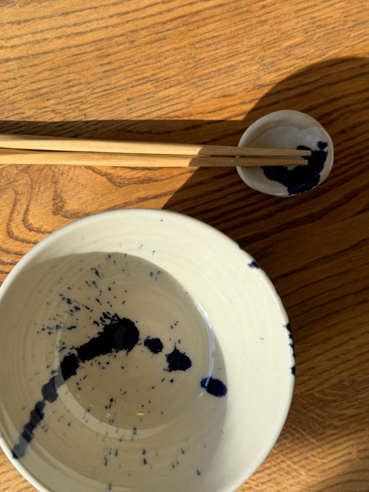 Rounded chopstick and matcha spoon rest in Gosu Series with cobalt blue splashes on wooden table, showcasing handmade craftsmanship.