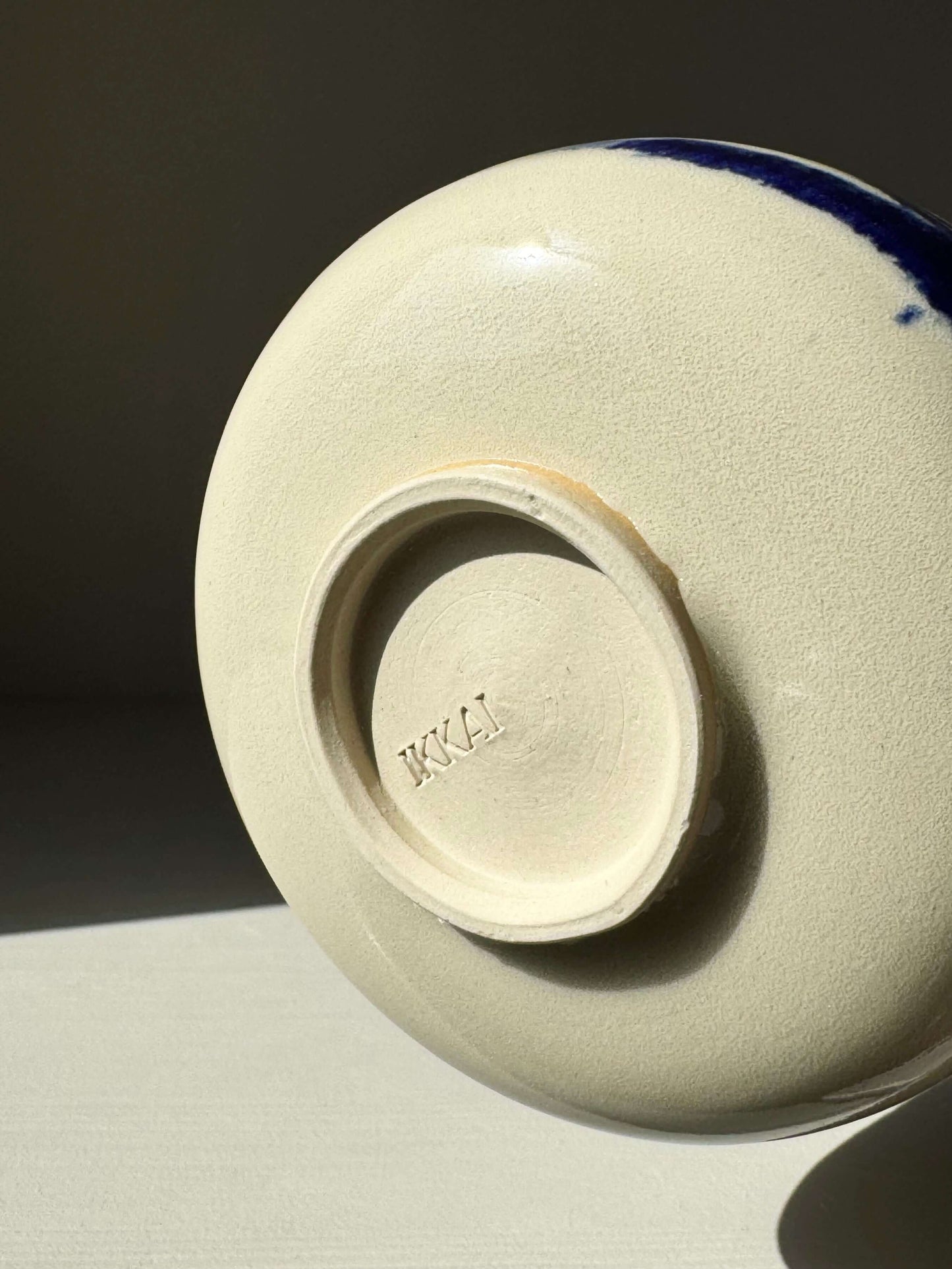 Base of Rounded Matcha Bowl, Gosu Series #02, showing indigo glaze and stamped signature in soft lighting.