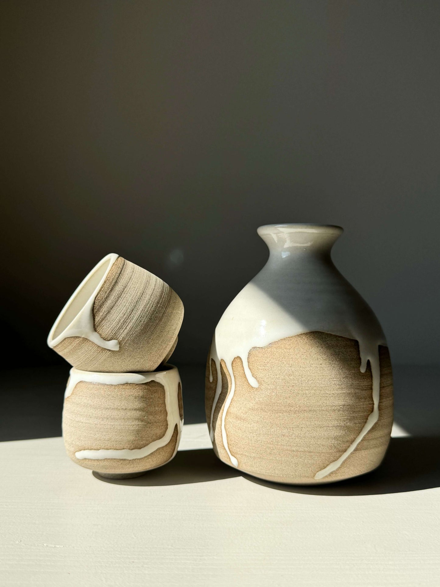 Sake Set from the Yuki Series with toffee clay and white glaze, featuring a bottle and two cups designed for everyday use.