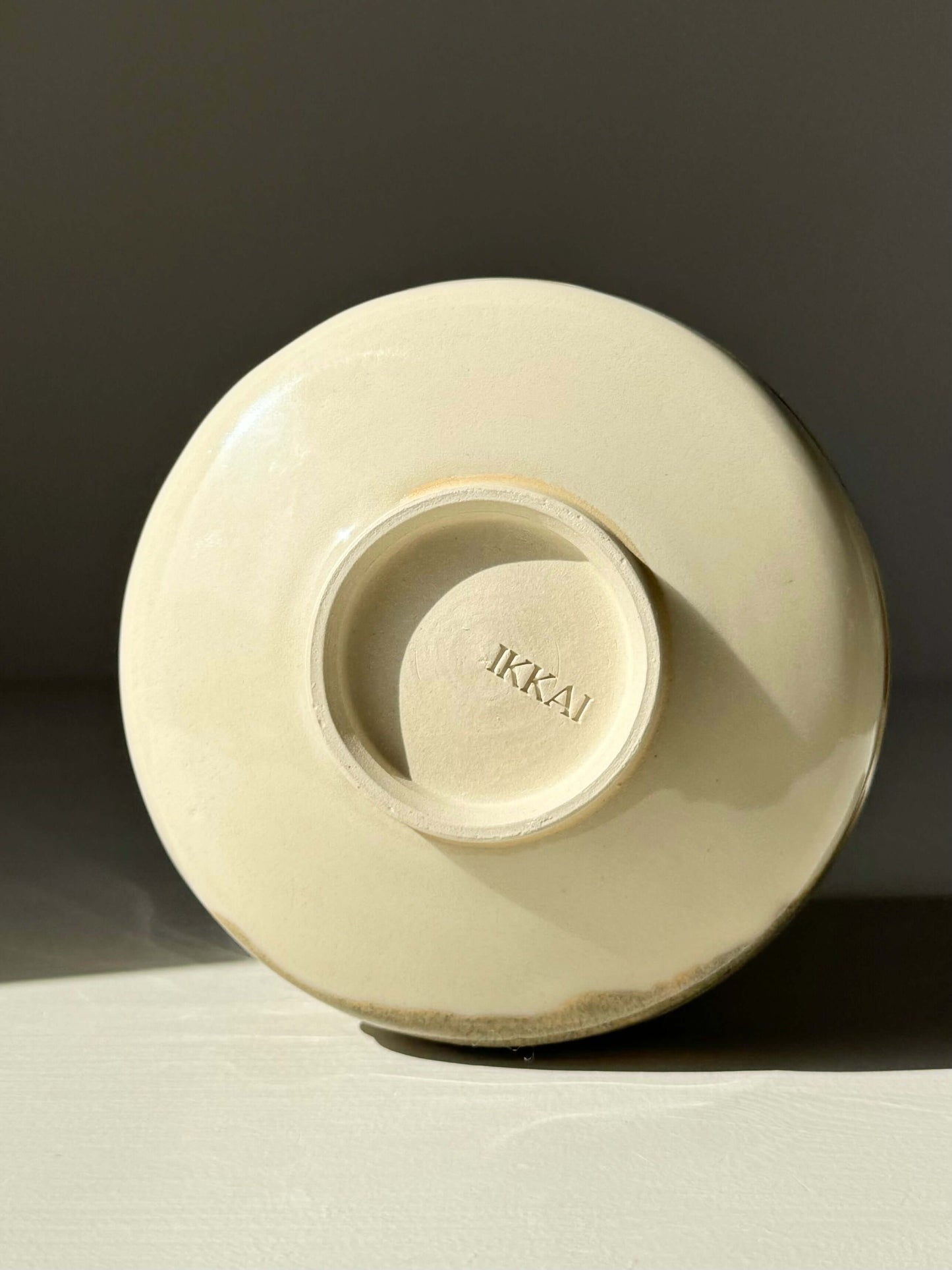 Base view of hand-thrown matcha bowl with clear glaze, showing potter's mark and unique tenmoku splash details.