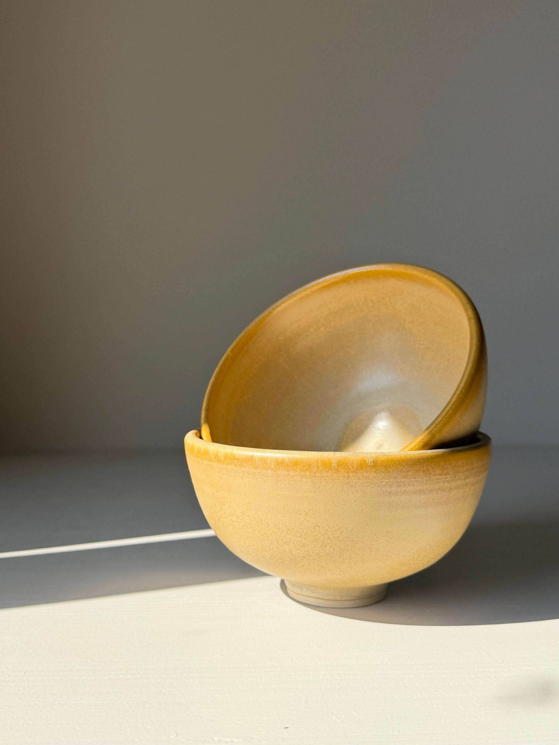 Small Bowl - Golden Yellow handmade ceramic with ochre glaze, showcasing hand-shaped details and speckled swirls on a soft foot.