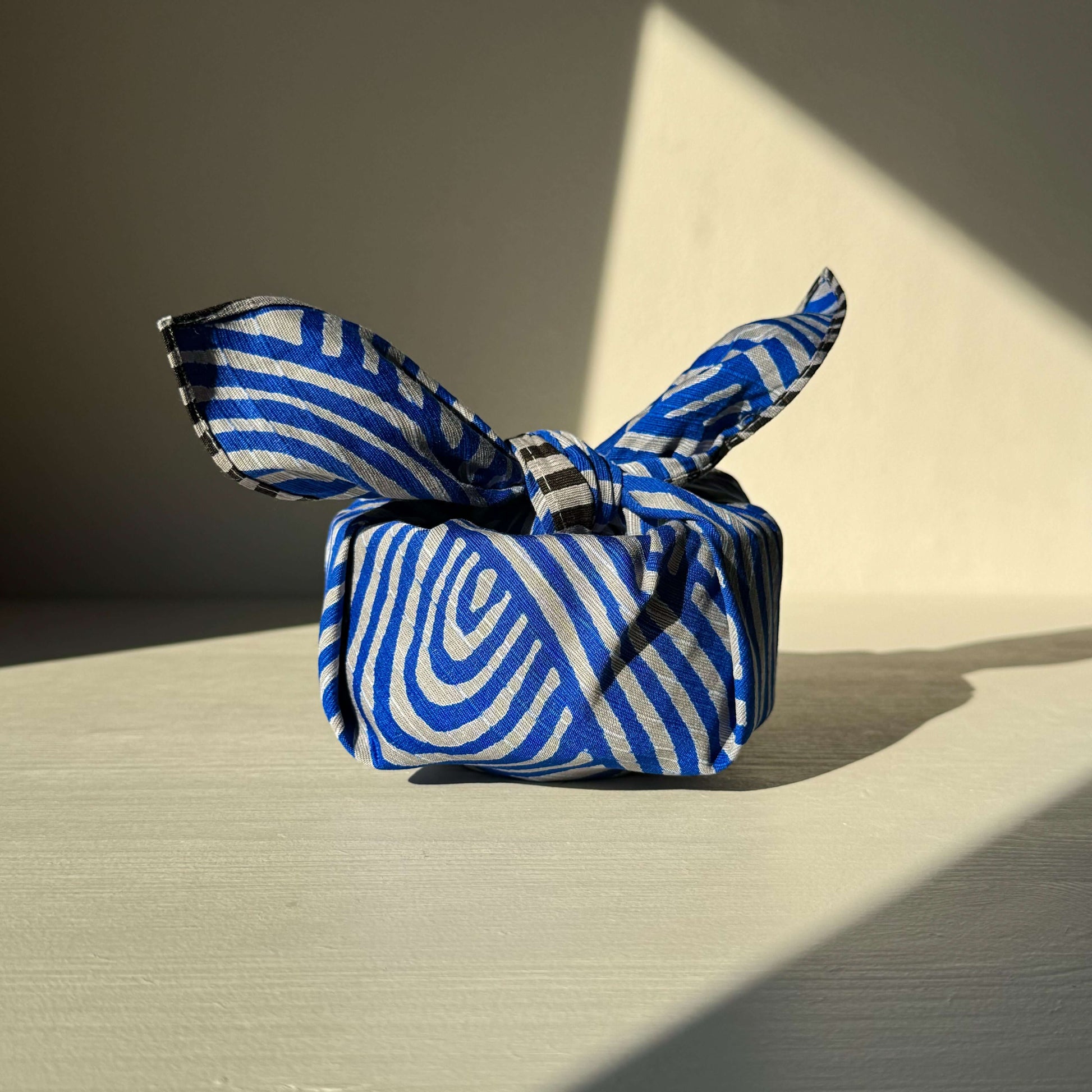 Small Furoshiki in dark gray and blue wrap, showcasing unique Isa Monyo inspired design. Perfect for eco-friendly wrapping. 48 cm x 48 cm.