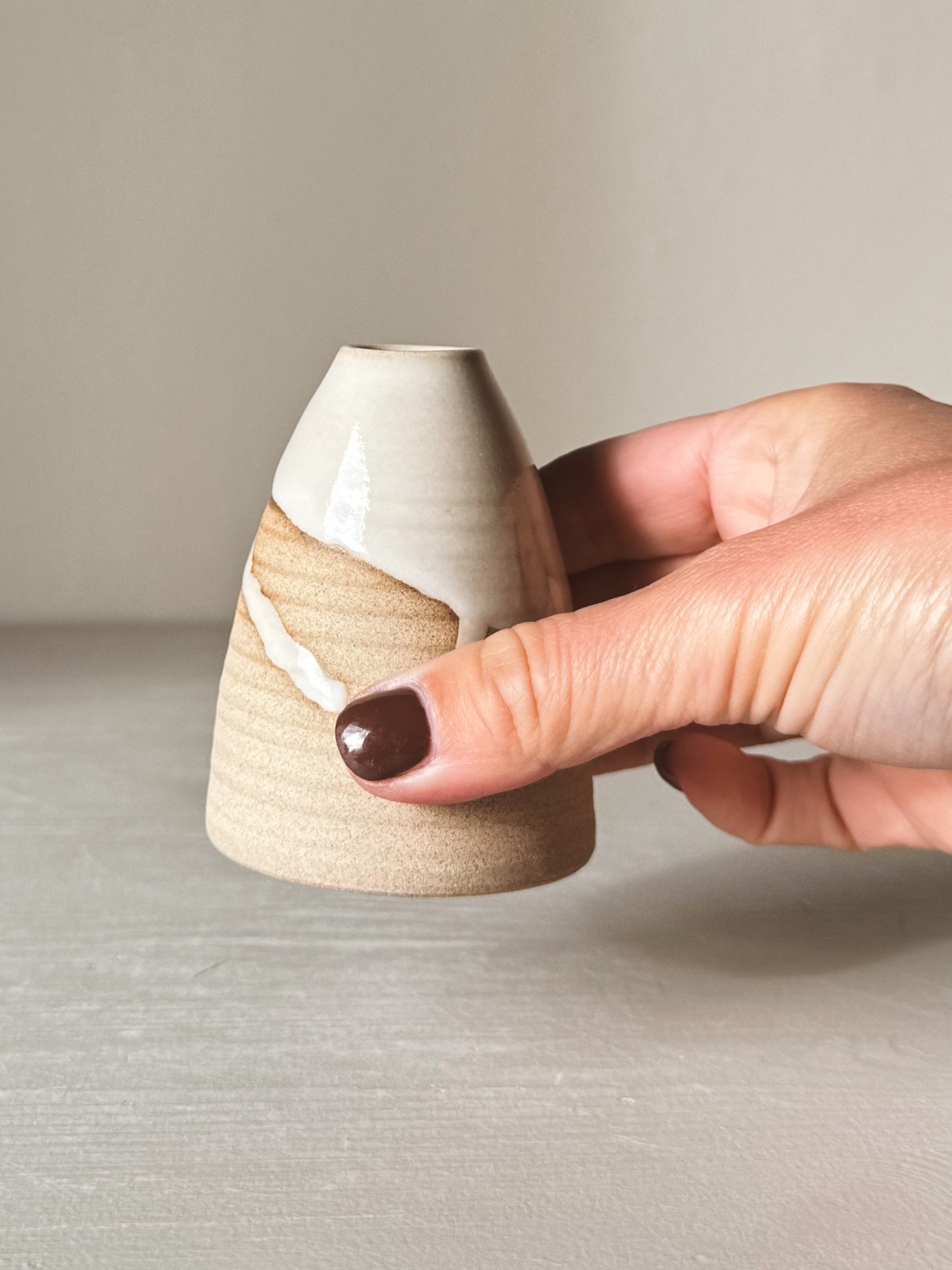 Person holding Small Vase – Yuki #02 with white glaze and sand clay finish, showing its small size and elegant craftsmanship.