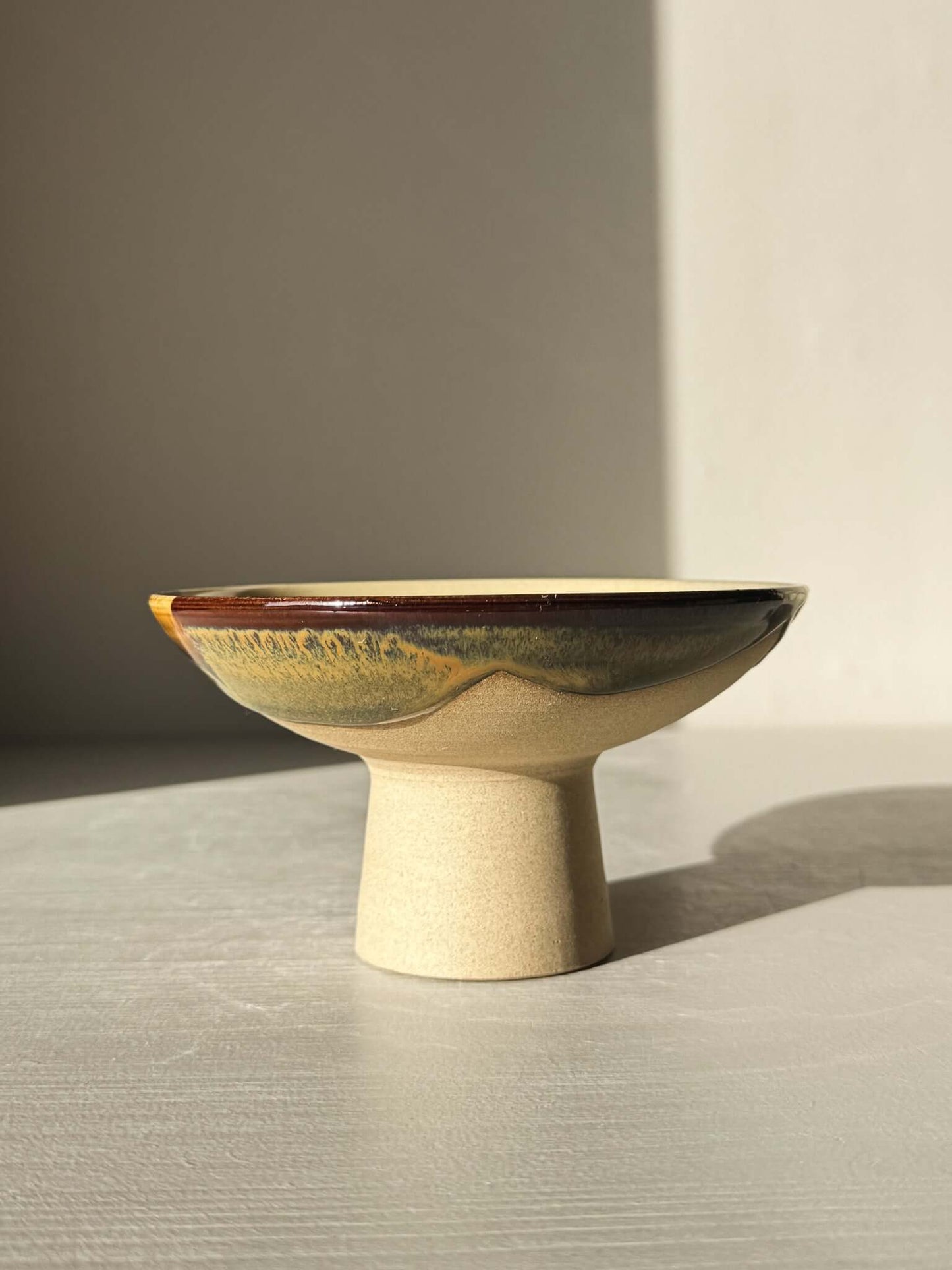 Small Pedestal Bowl - Inyo #01 with warm gold, rich brown, blue, and green glaze on tall footed design, sculptural and elegant.