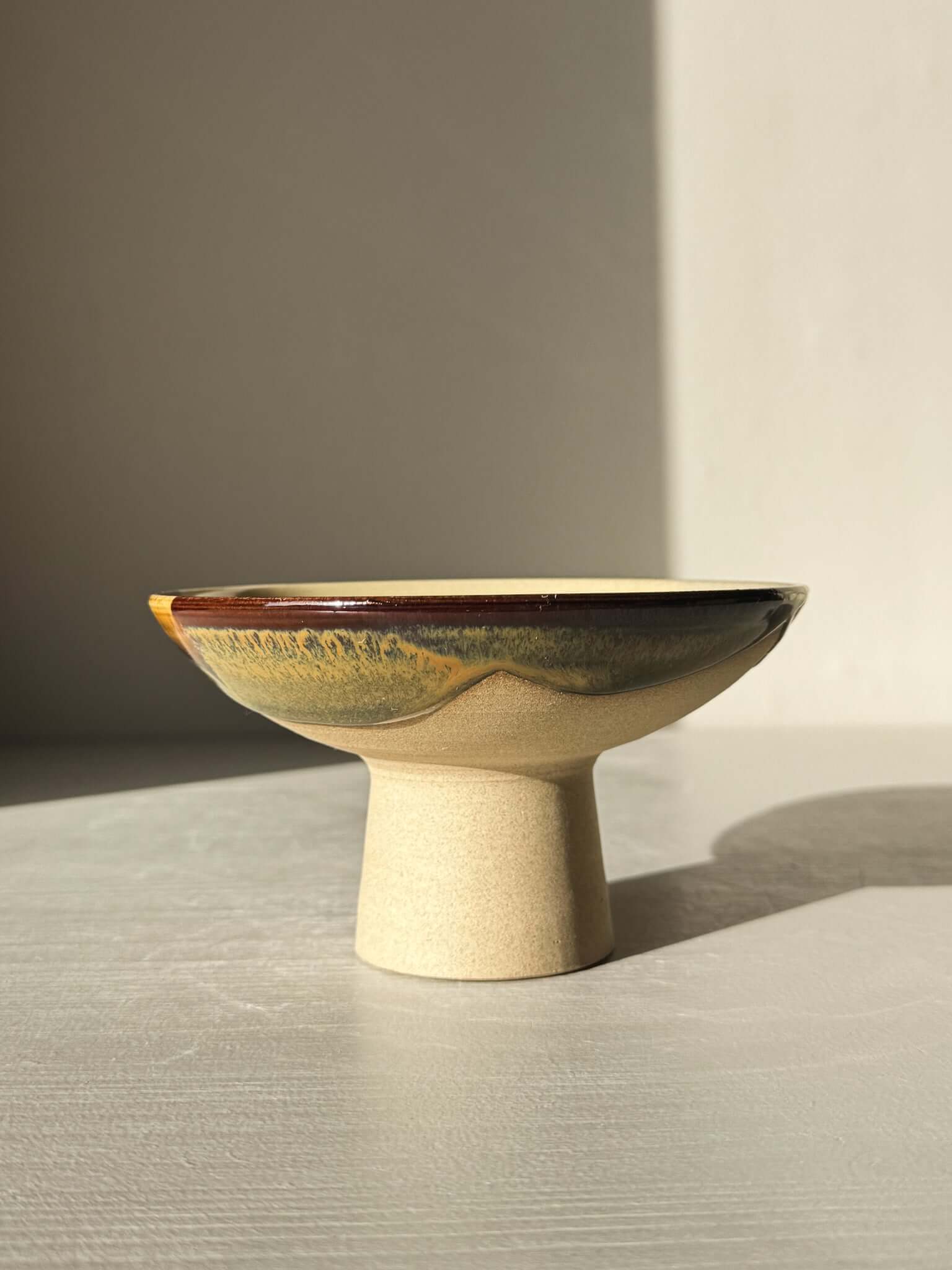Small Pedestal Bowl - Inyo #01 with warm gold, rich brown, blue, and green glaze on tall footed design, sculptural and elegant.