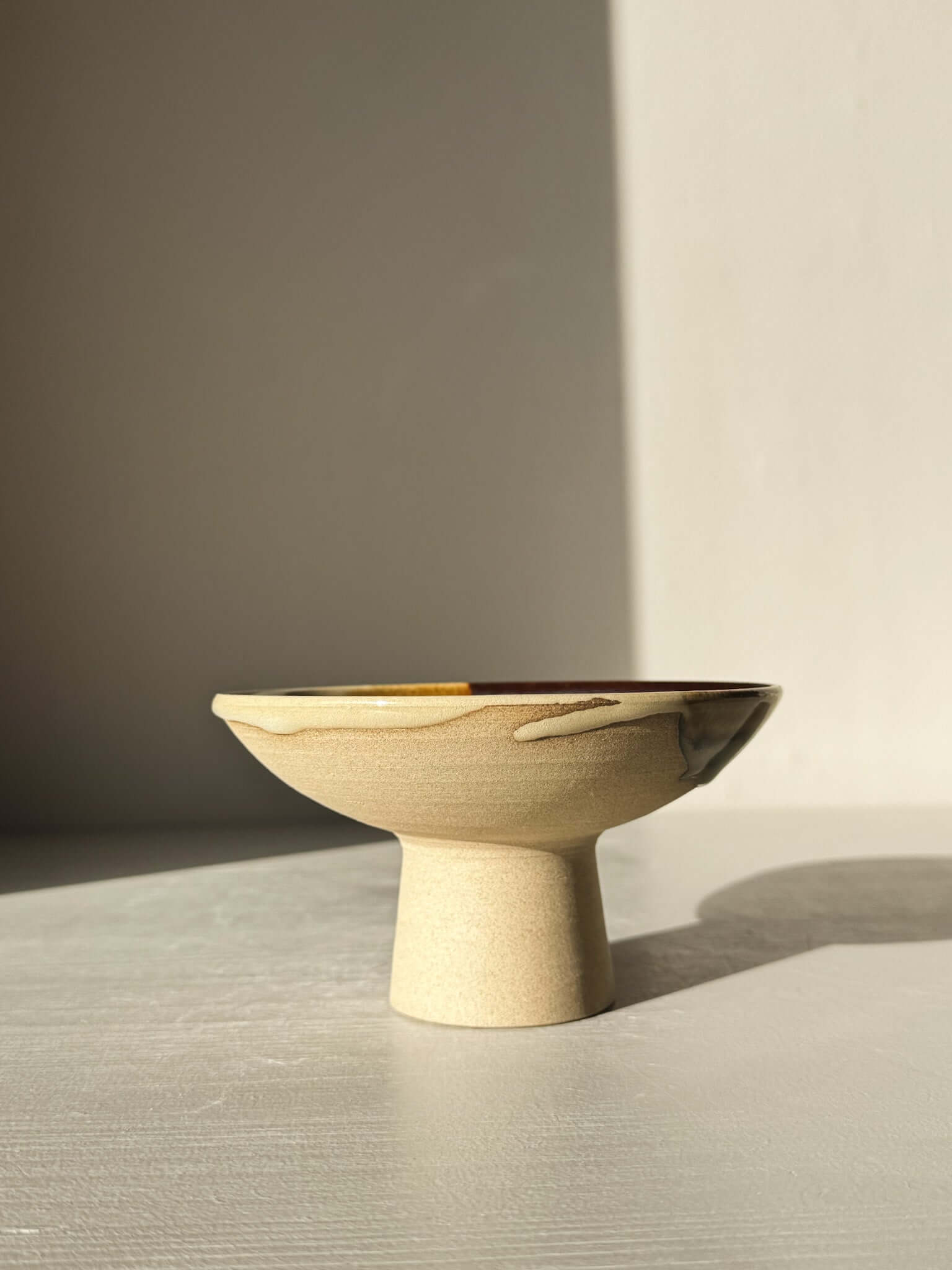 Small Pedestal Bowl - Inyo #01 with elegant sculptural design and glazed in warm gold, rich brown, blue, and gentle green hues.