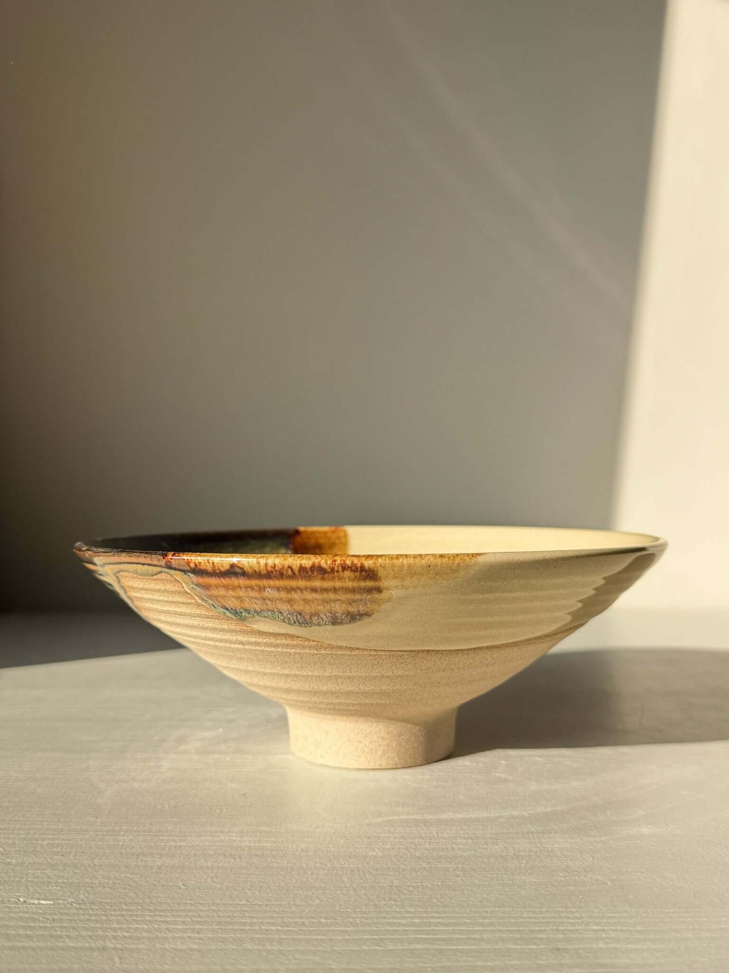 Small Serving Bowl - Inyo Series #01 handmade ceramic with tenmoku and amber glaze on a sunlit surface.