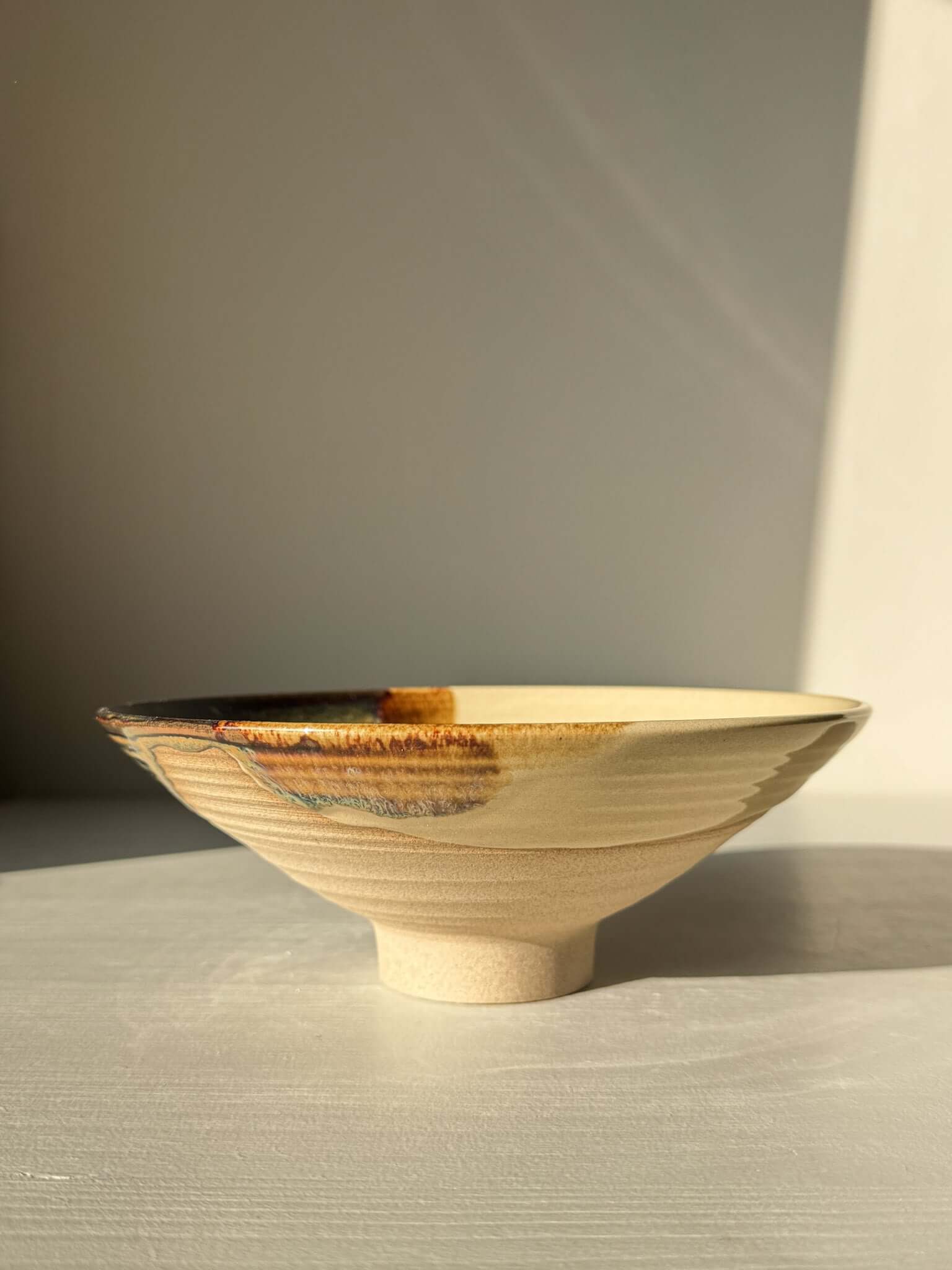 Small Serving Bowl - Inyo Series #01 handmade ceramic with tenmoku and amber glaze on a sunlit surface.