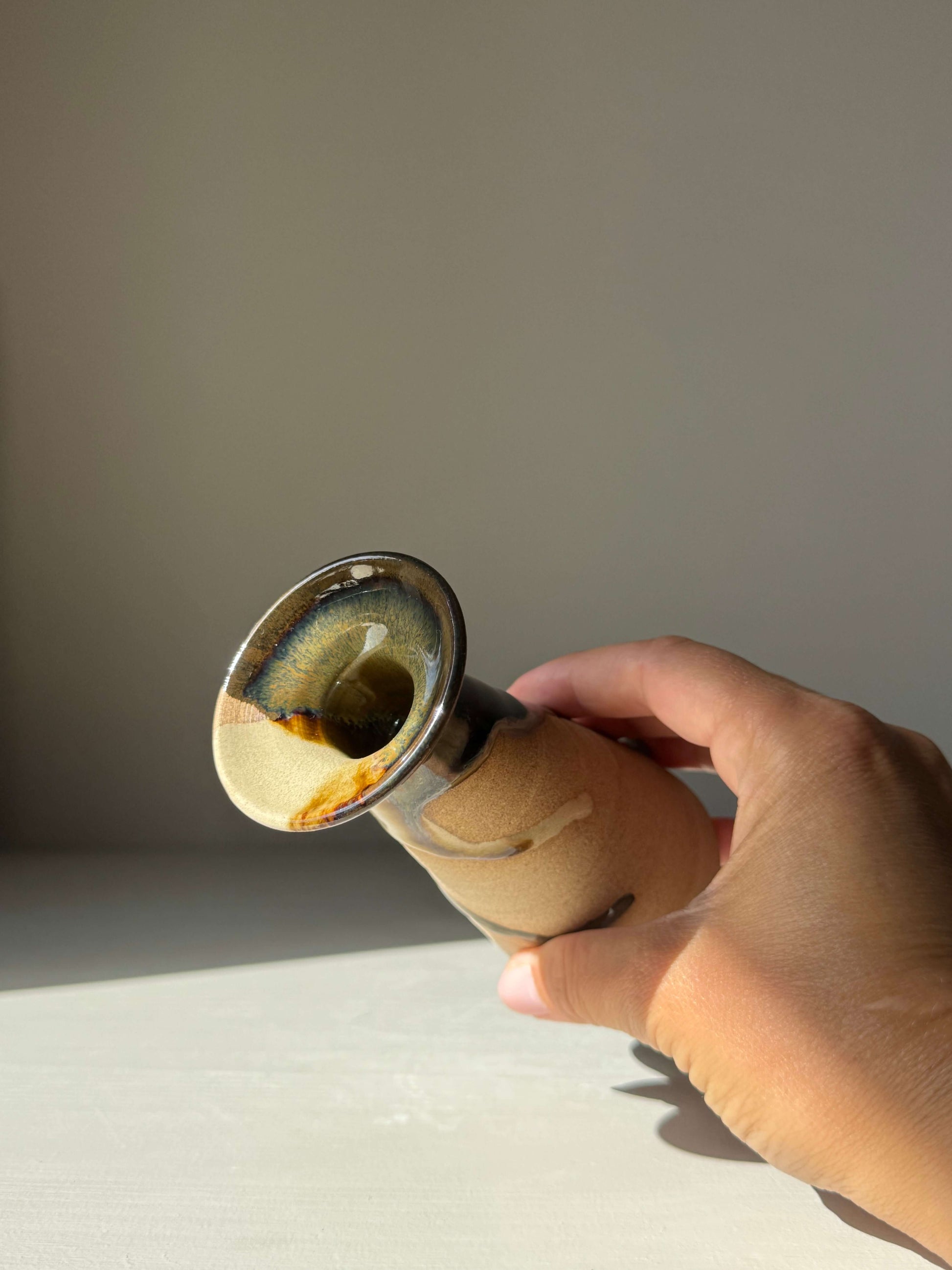 Hand holding Small Vase – Inyo #01, a handmade ceramic piece with a sculptural silhouette and unique glaze pattern.