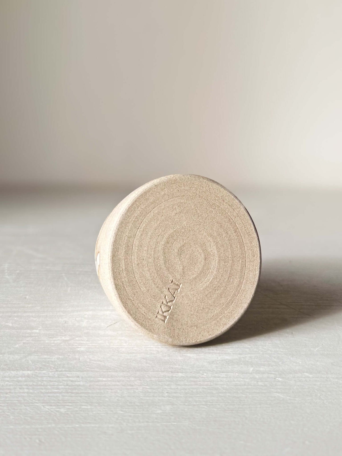 Bottom view of Small Vase – Yuki #01 with matte raw clay base and subtle circular patterns on a light surface.