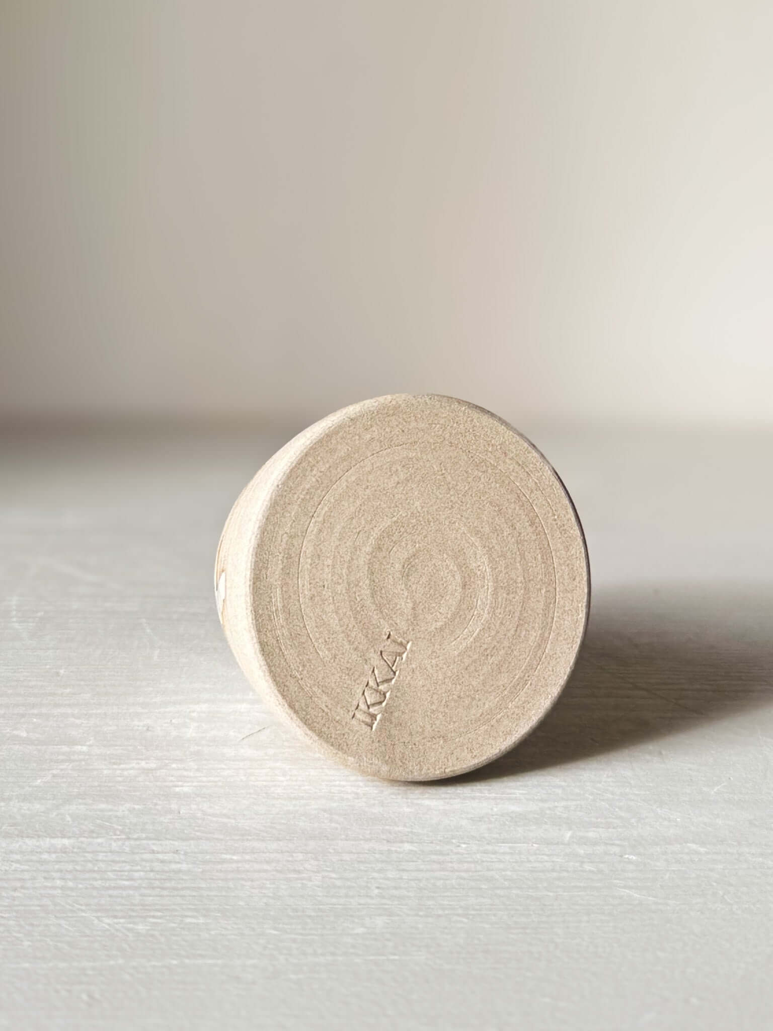 Bottom view of Small Vase – Yuki #01 with matte raw clay base and subtle circular patterns on a light surface.