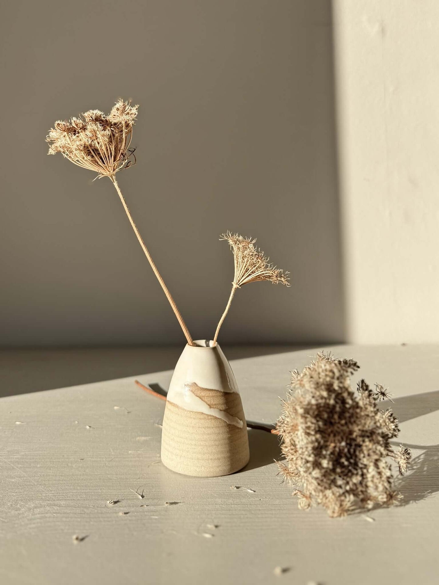 Small Vase – Yuki #02 with dried flowers, showcasing soft curves and white glaze on a warm clay base.