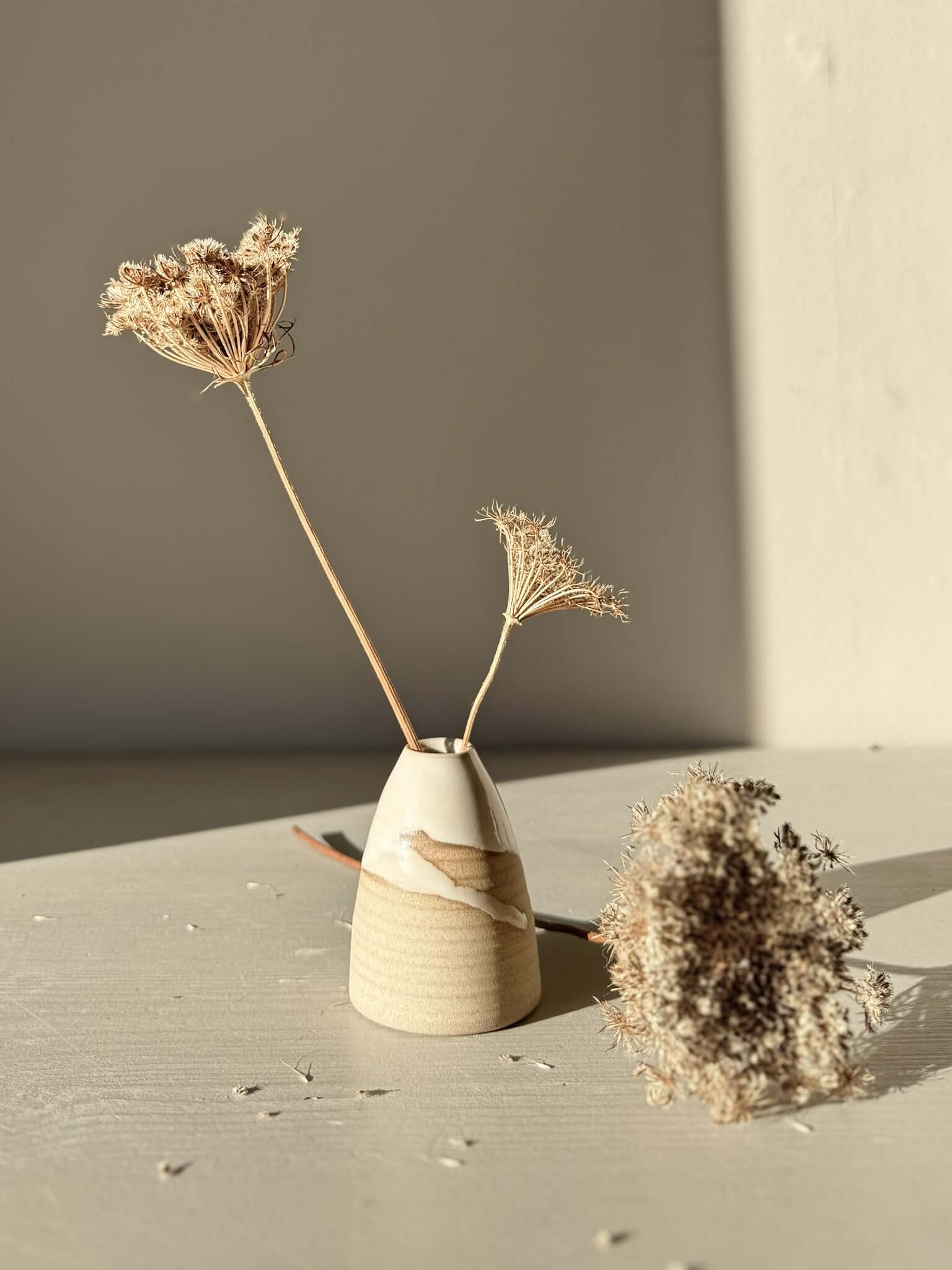 Small Vase – Yuki #02 with dried flowers, showcasing soft curves and white glaze on a warm clay base.