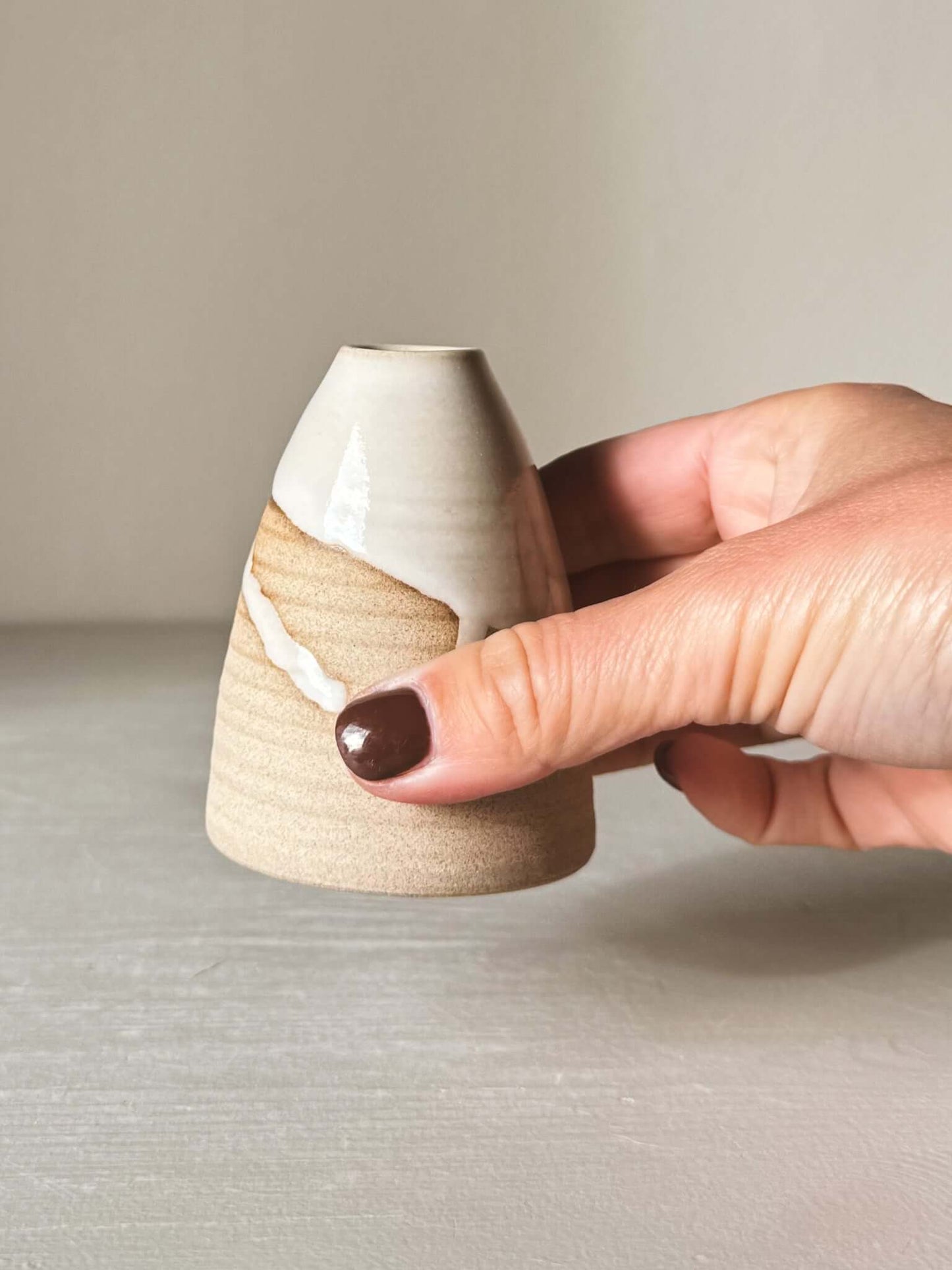 Person holding Small Vase – Yuki #02 with white glaze and sand clay finish, showing its small size and elegant craftsmanship.