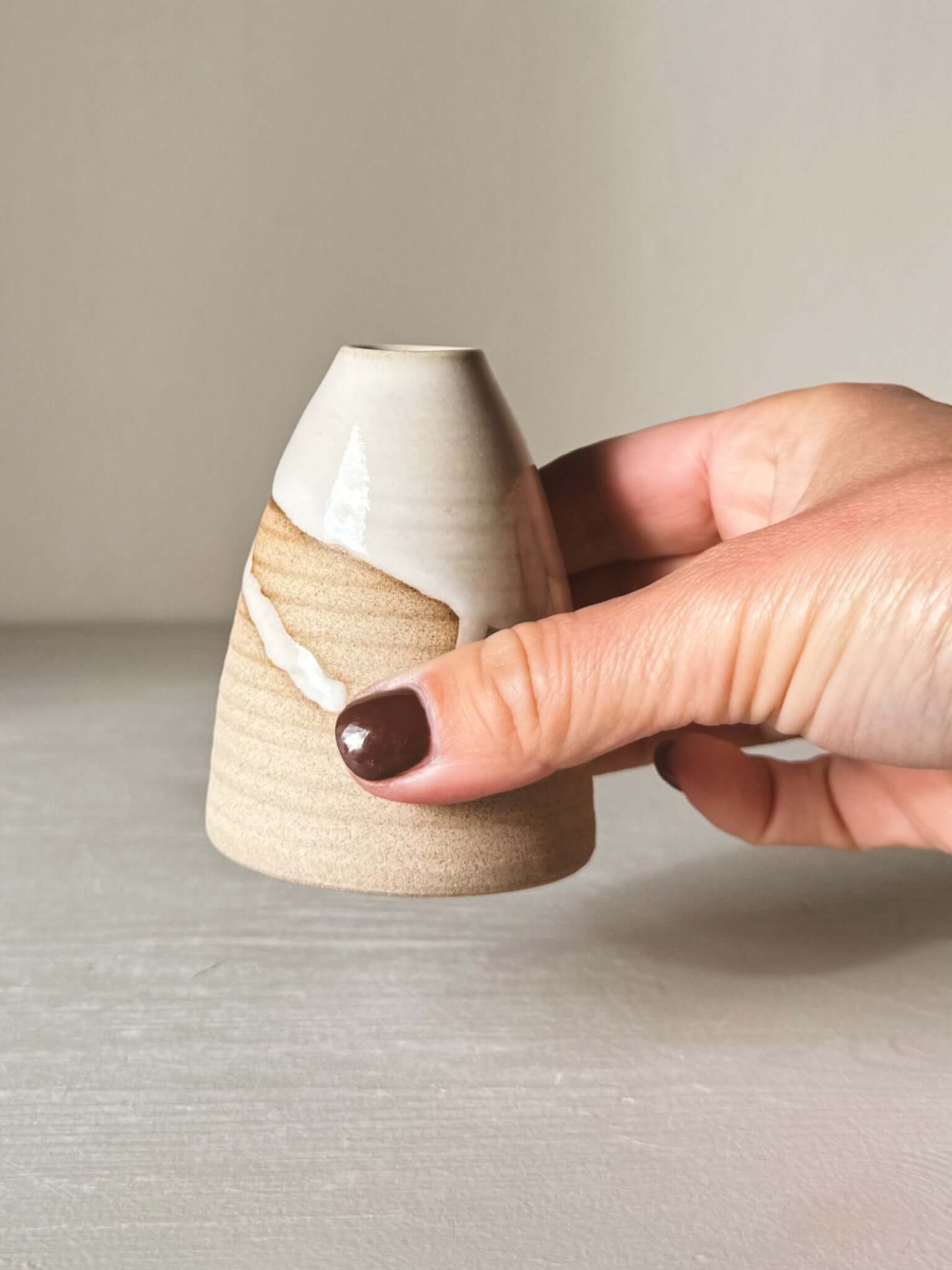 Person holding Small Vase – Yuki #02 with white glaze and sand clay finish, showing its small size and elegant craftsmanship.
