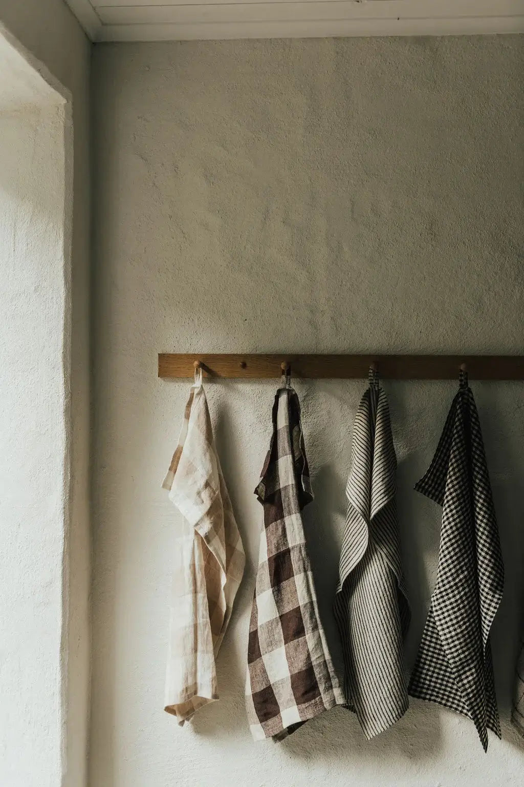 Striped Linen Kitchen Towel - 100% linen hanging with handmade ceramic aesthetic in a cozy kitchen setting.