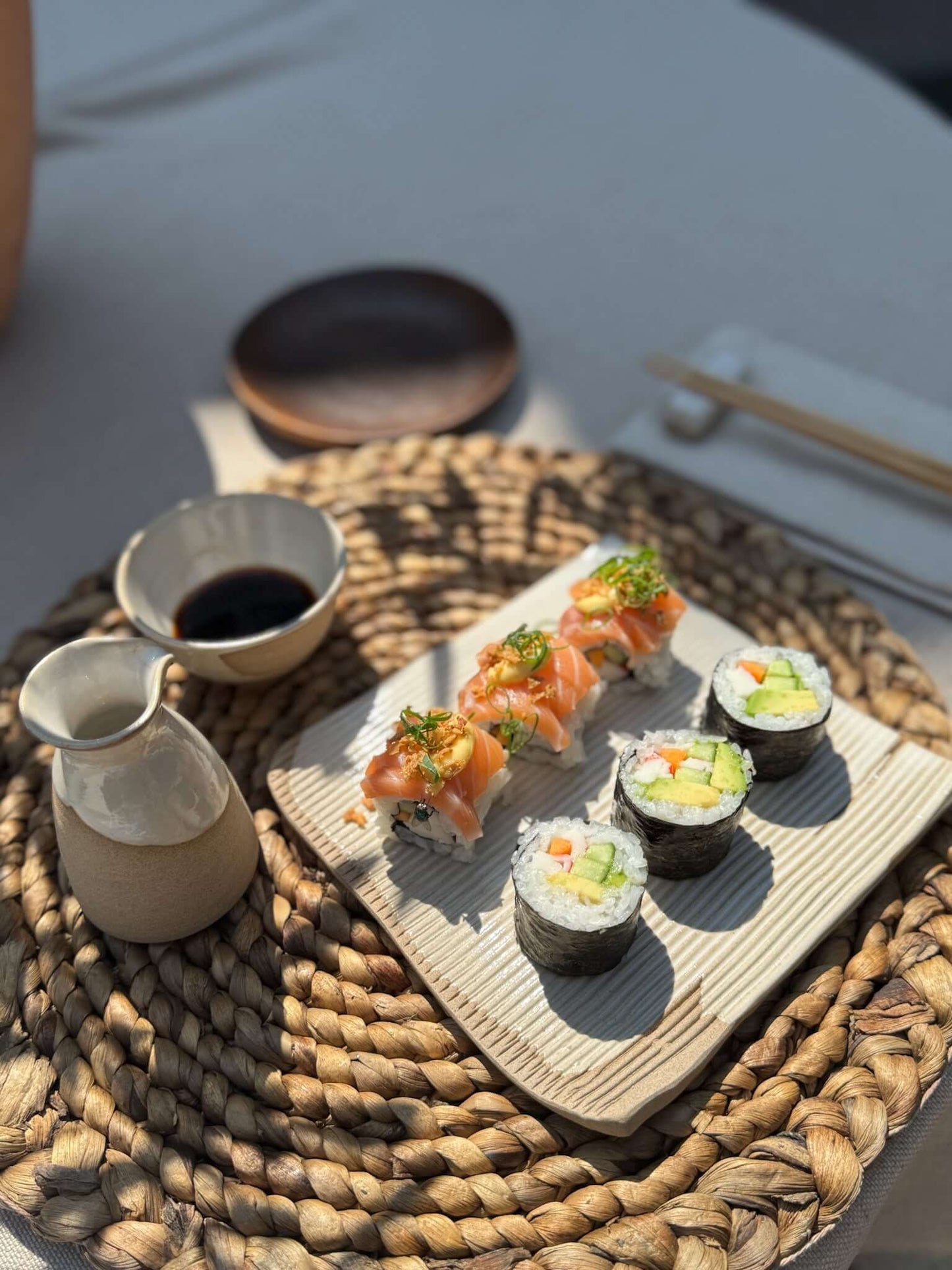 Sushi Plate – Yuki #01 showcasing handmade ceramic with artisan sushi rolls on a woven mat, highlighting texture and calm design.