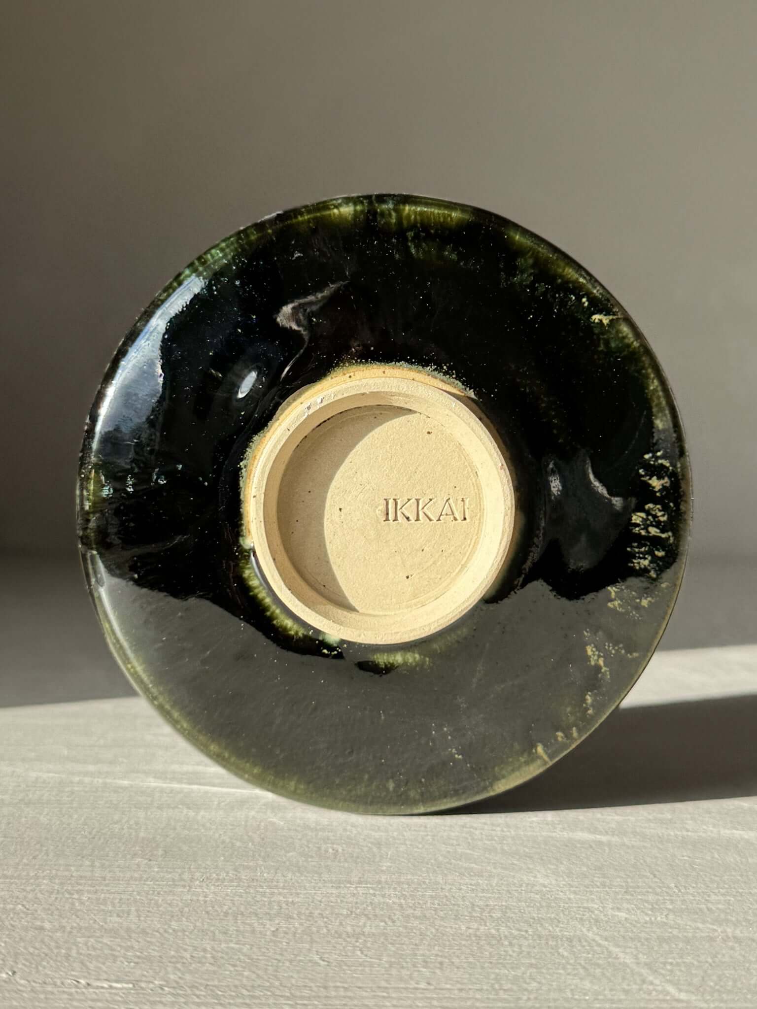 Bottom view of Textured Matcha Bowl Spout - Hinoki #01 with glossy green glaze and subtle ridges highlighting the craftsmanship.