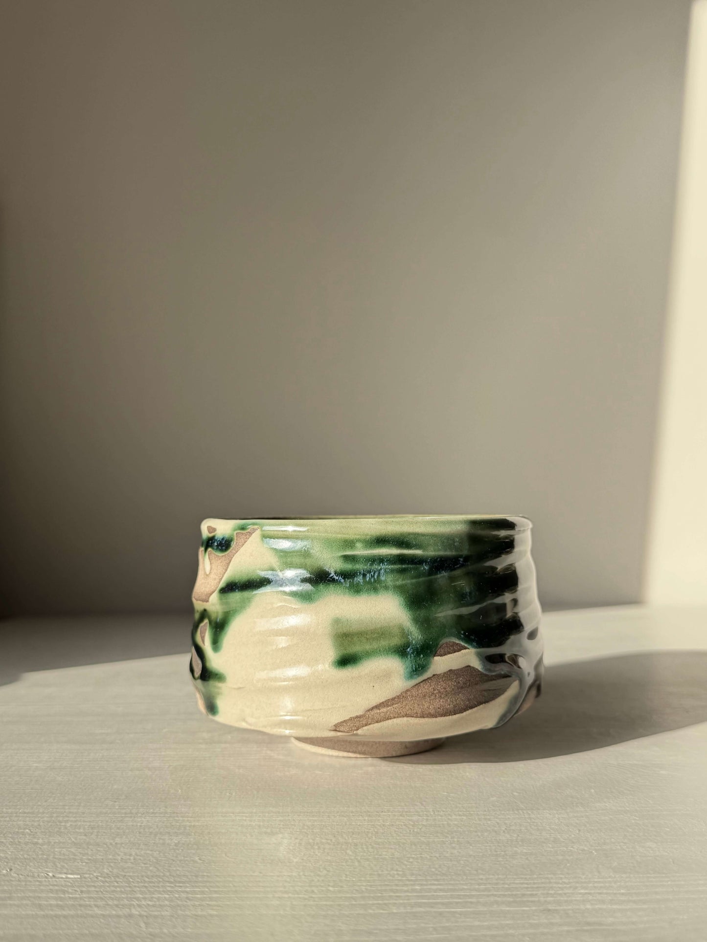 Textured Matcha Bowl – Mori #02, handmade ceramic bowl with organic texture and glossy forest-green glaze on natural clay surface