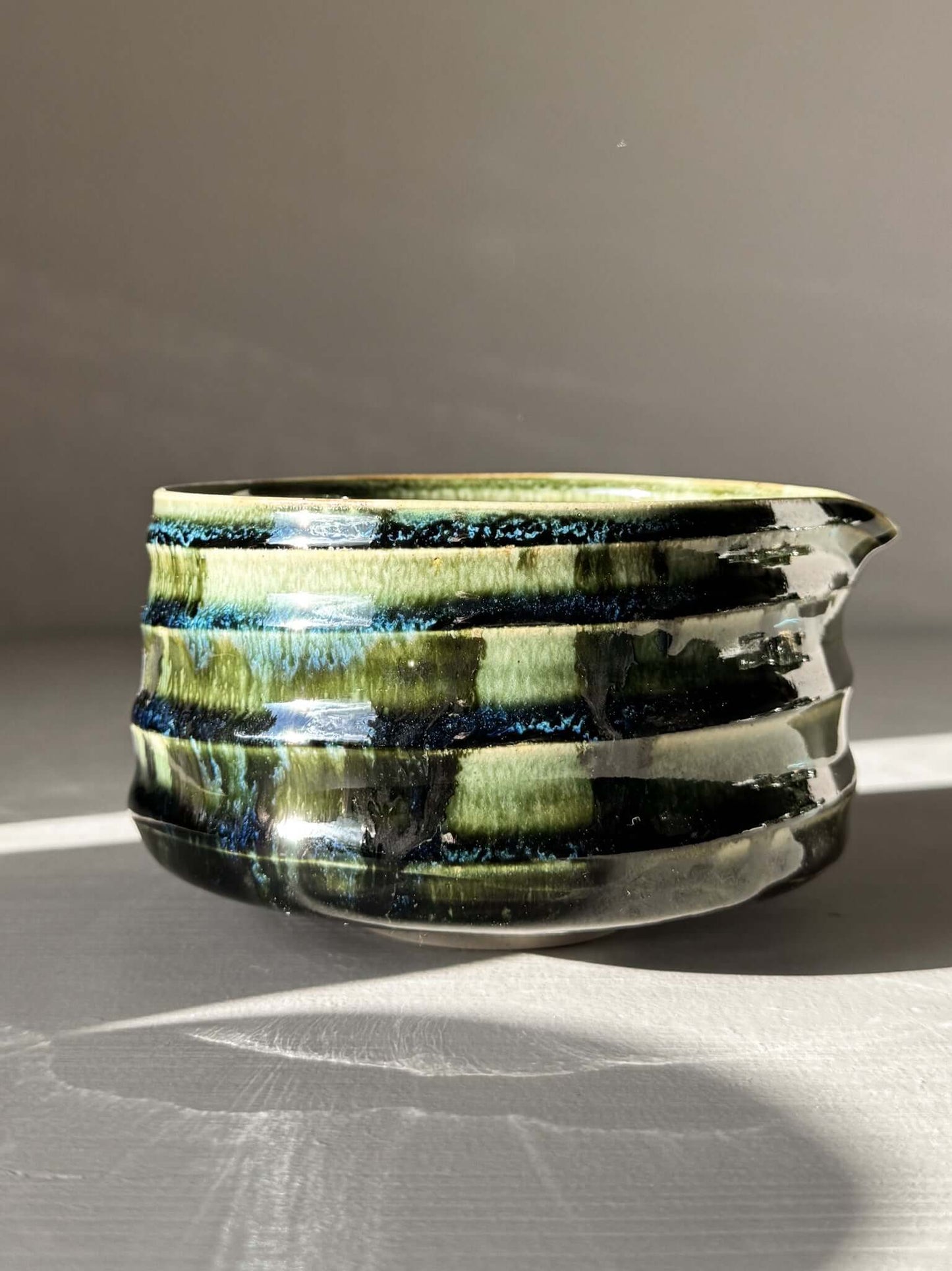 Textured Matcha Bowl Spout - Hinoki #03 with glossy green glaze and pouring spout, highlighting its unique tactile ridges and surface texture.
