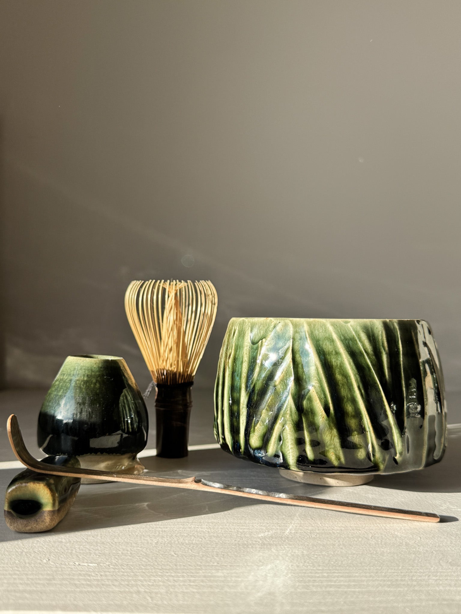 Textured Matcha Bowl - Hinoki #08 with green glaze, alongside matcha whisk and scoop, showcasing natural beauty and craftsmanship.