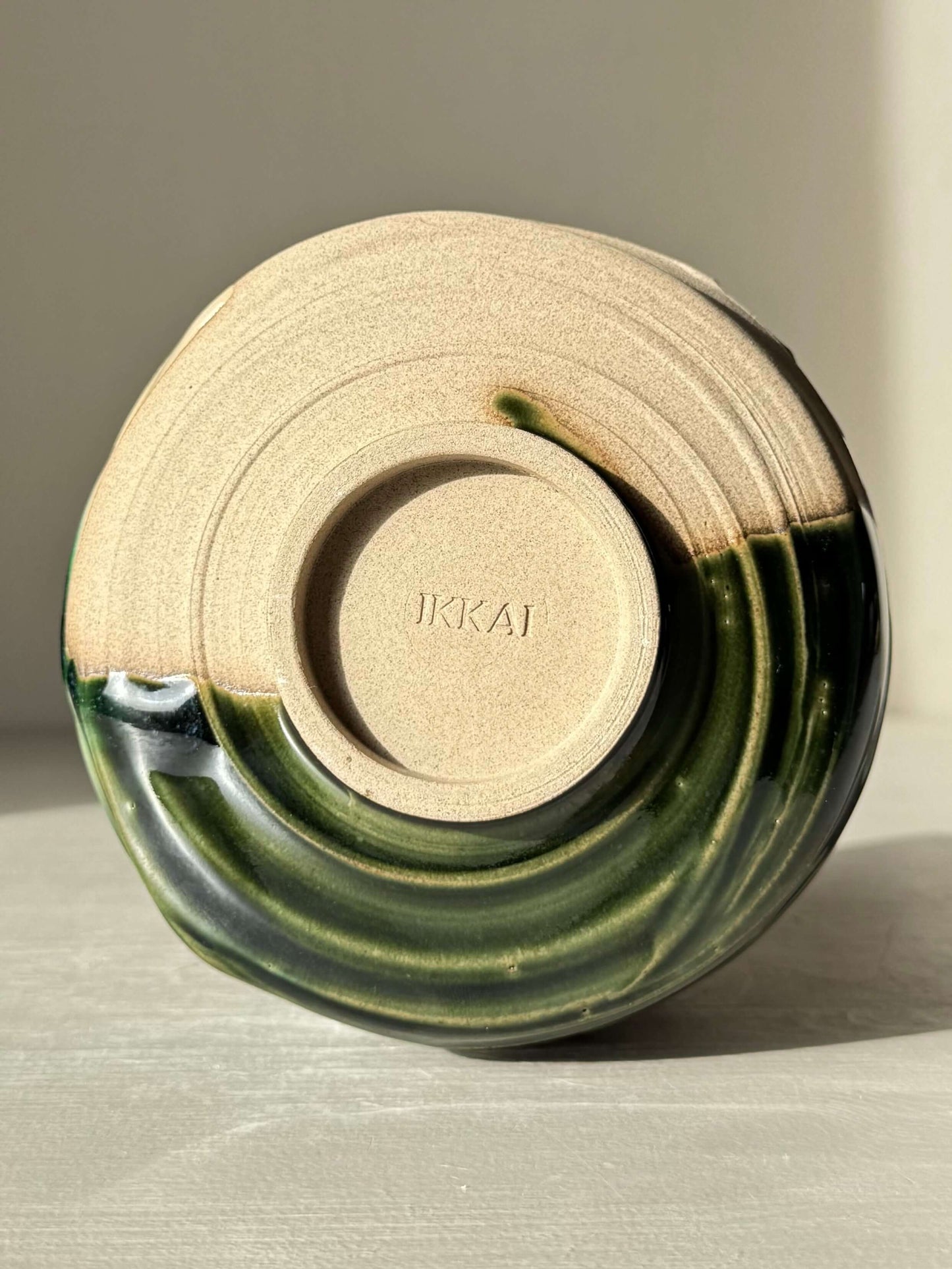 Base of Textured Matcha Bowl – Mori #01 showcasing handmade ceramic design with flowing green glaze and natural clay texture.