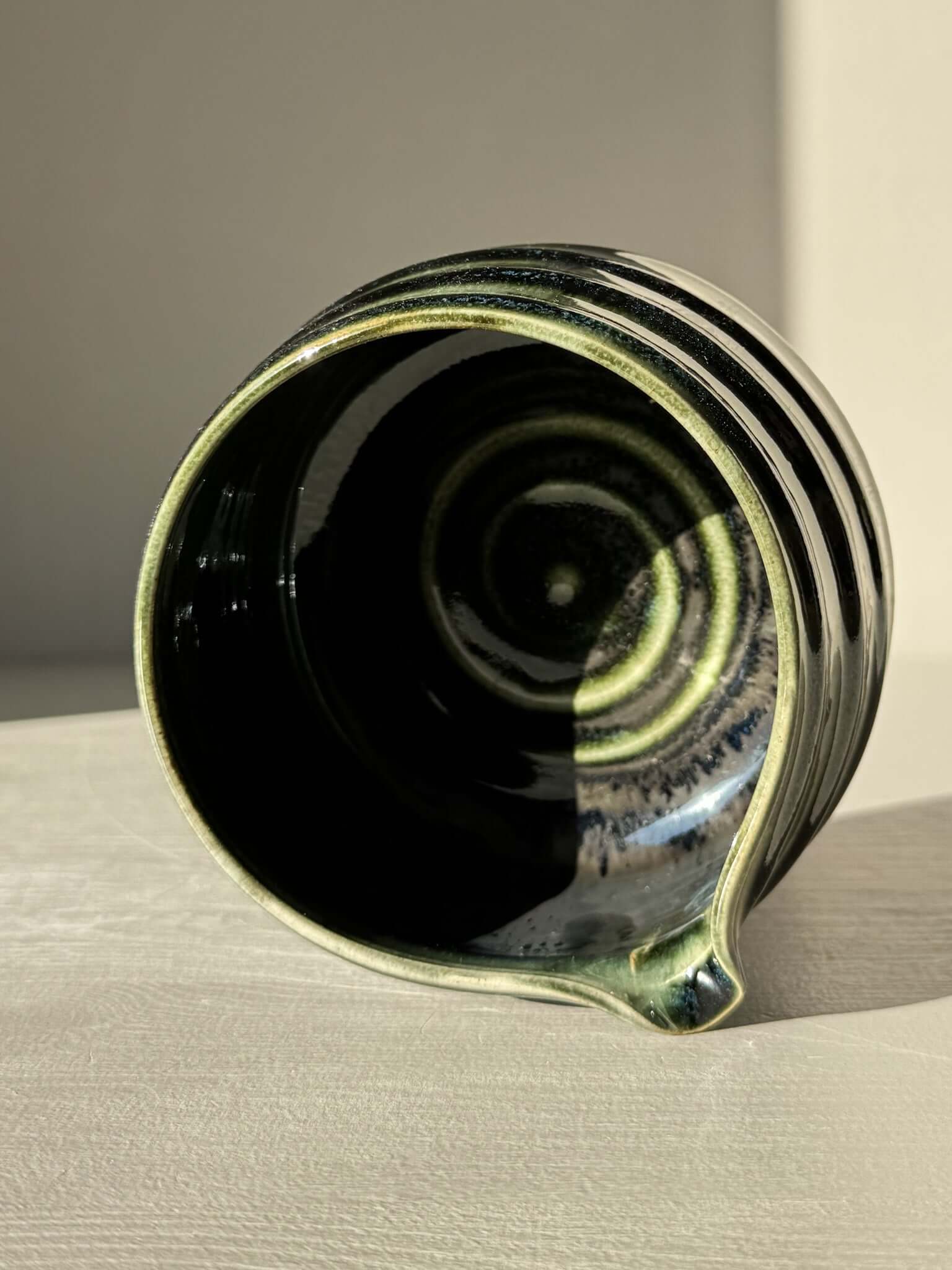 Top view of a Textured Matcha Bowl Spout - Hinoki #04 with glossy green glaze and subtle ridges.