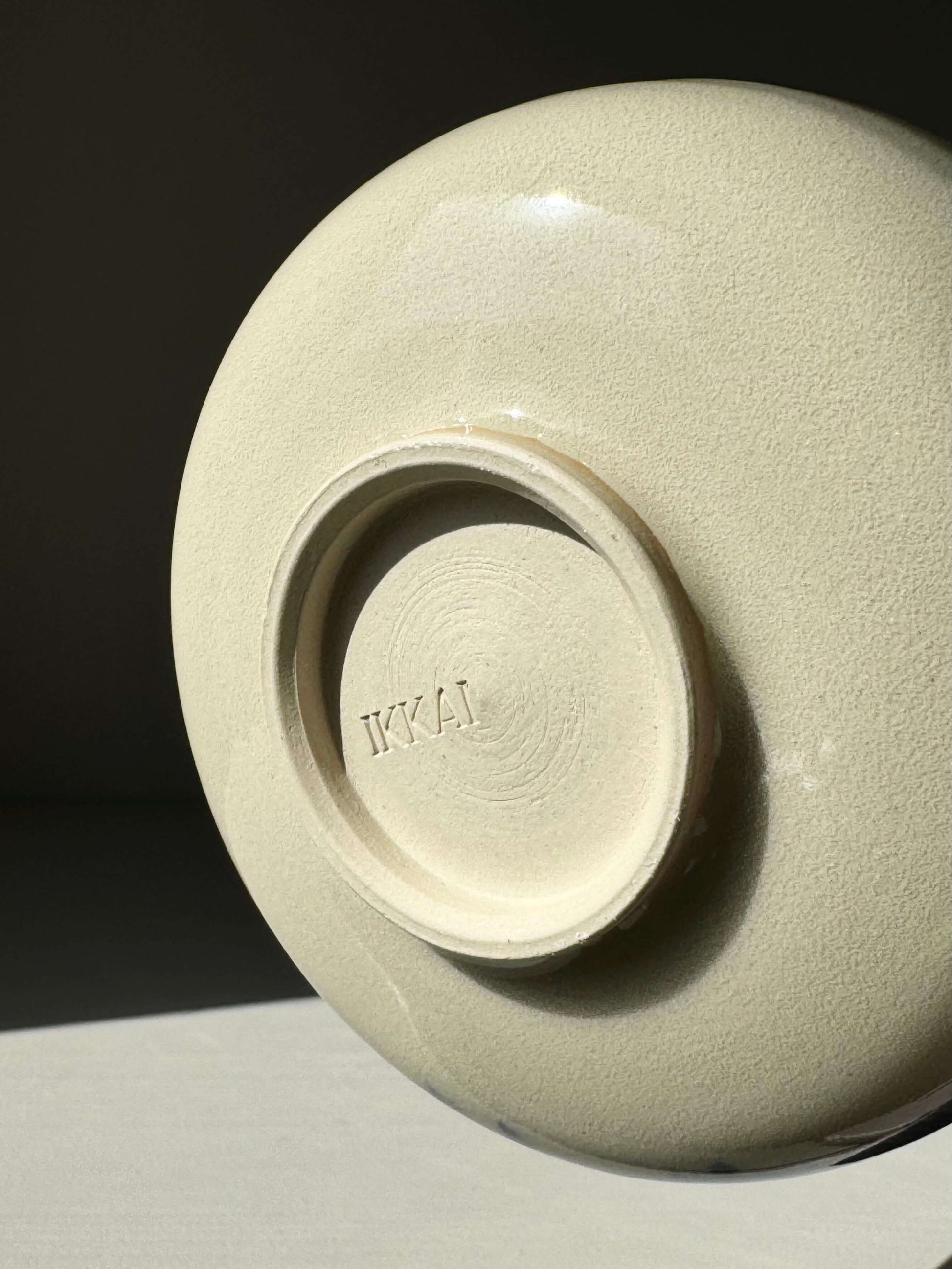Base of the Rounded Matcha Bowl – Gosu Series #03 showing smooth ceramic finish and embossed branding under soft lighting.