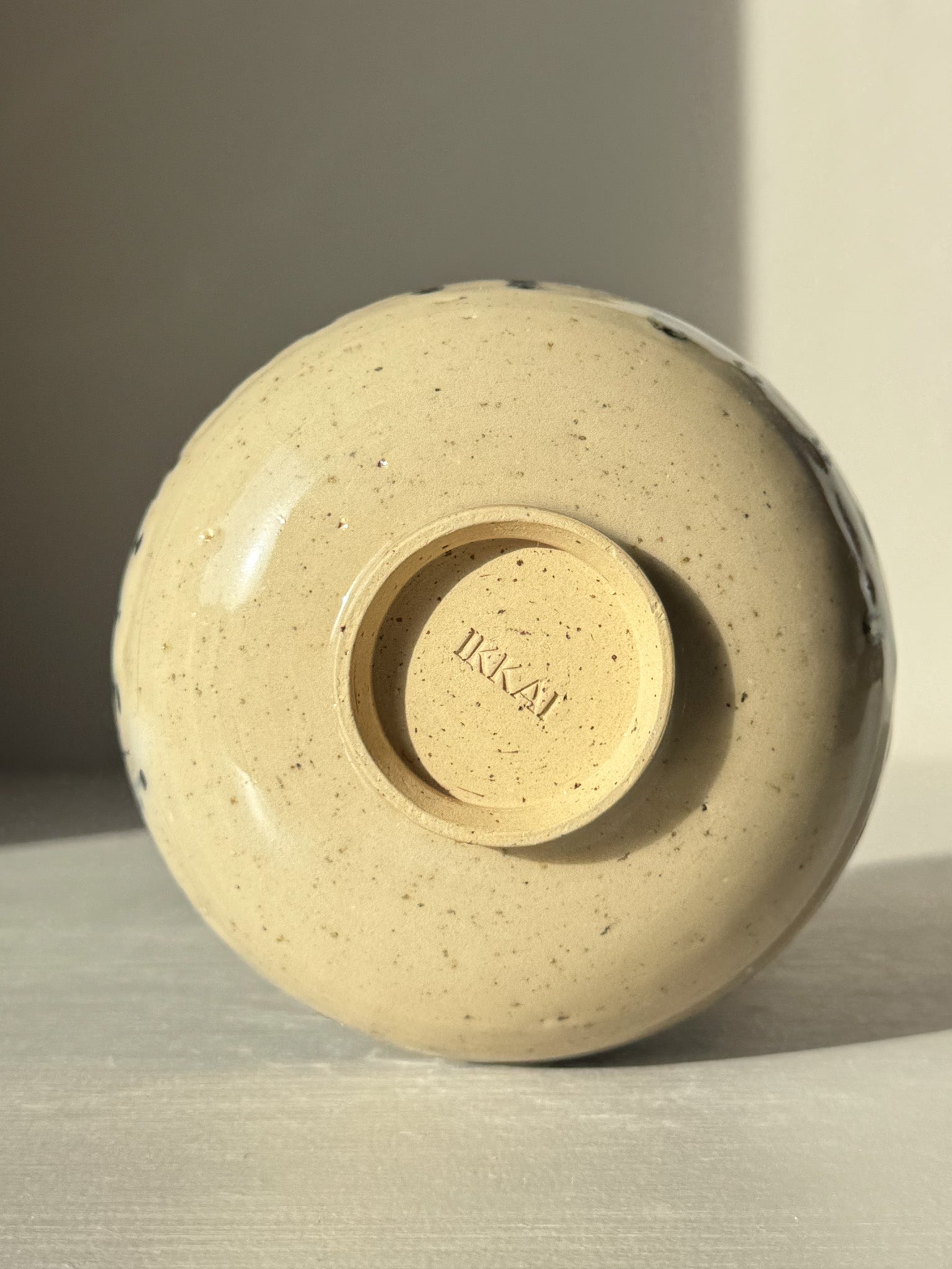 Underside view of ceramic bowl showing maker's mark and textured finish