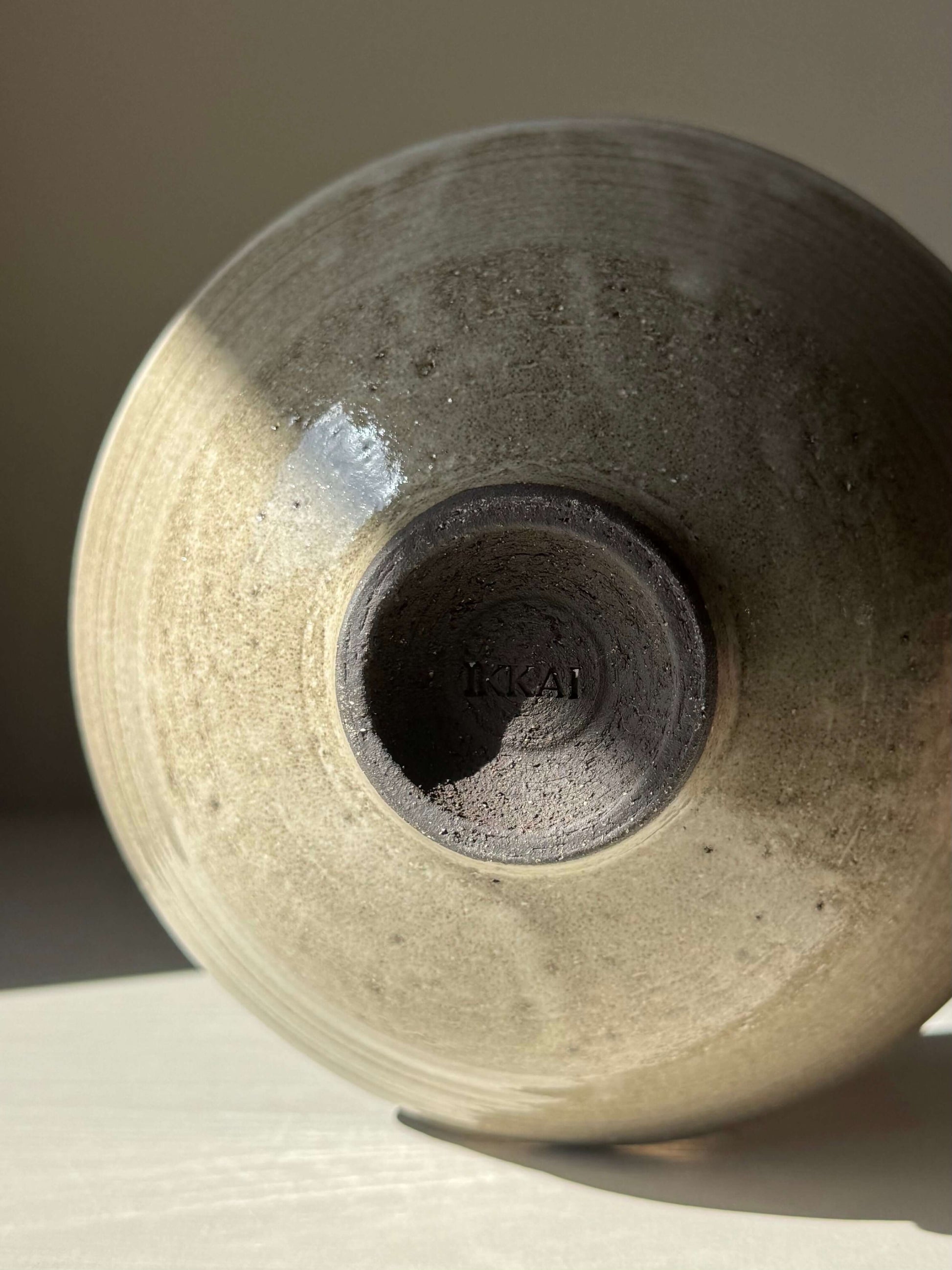 Bottom view of handmade ceramic Bowl – Yuki Series Dark Clay, showcasing trimmed foot and unique glaze texture.