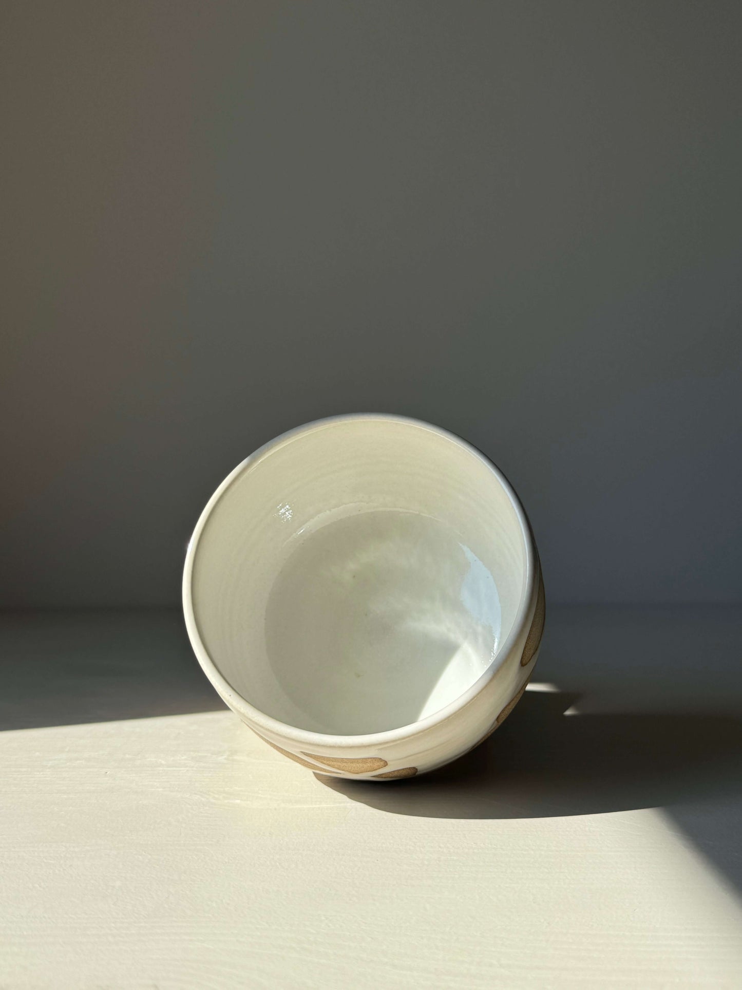 Handmade Matcha bowl from Yuki Series #04 with toffee clay and white glaze, showcasing unique drips and natural settlement.