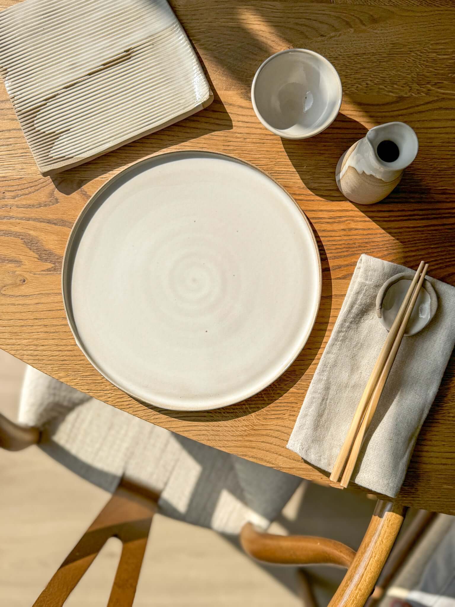 Flat Round Plate – Yuki Series handmade ceramic with soft white glaze on wooden table setting.