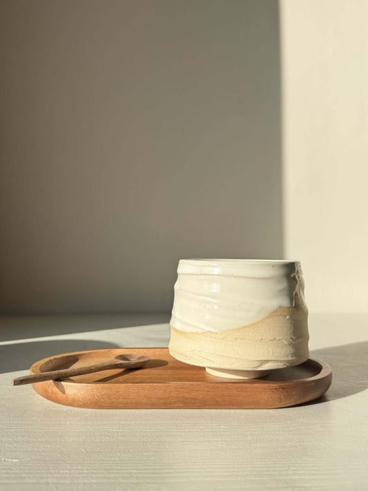 Yunomi Cup – Glossy White #01 on a wooden tray with spoon, perfect for warm beverages, showcasing elegant soft curves and a natural glaze.