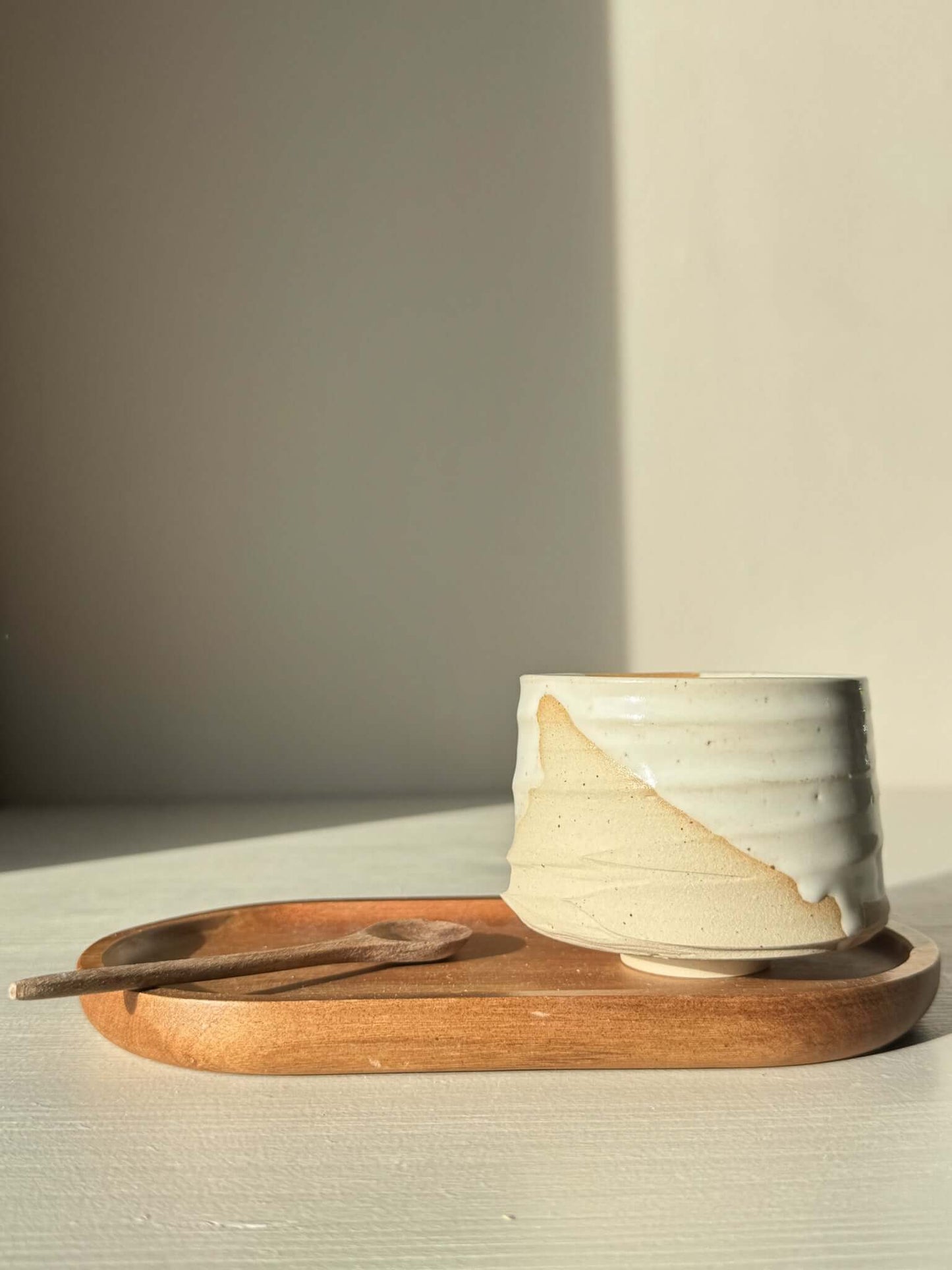 Yunomi Cup – Glossy White #03 with flowing glaze finish, perfect for sipping tea or coffee, displayed on a wooden tray with a spoon.