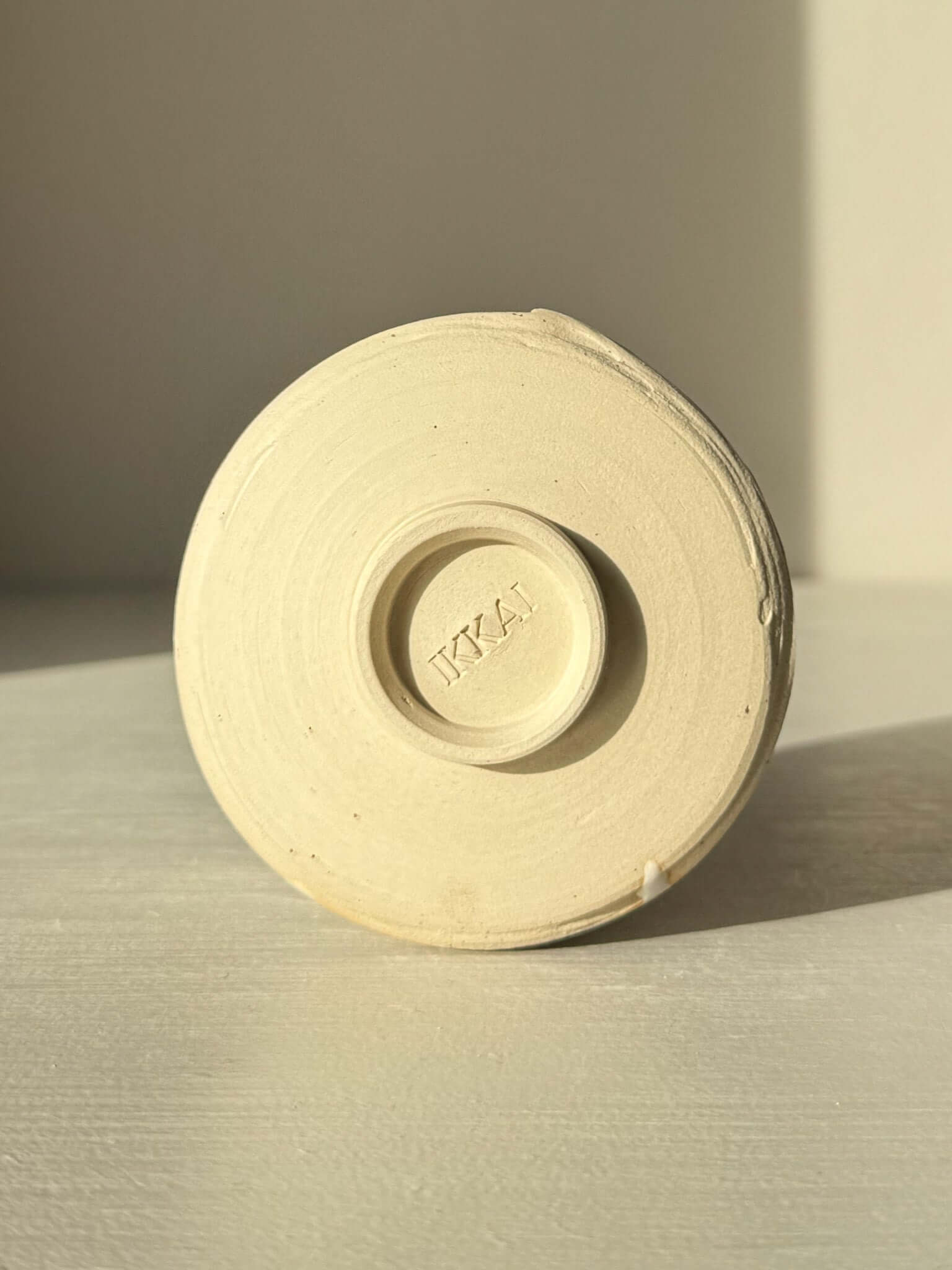 Underside view of Yunomi Cup – Glossy White #03 showing base design and glaze texture