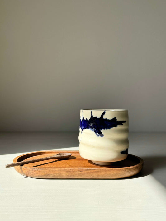 Yunomi Cup from the Gosu Series with bold cobalt blue splashes, handcrafted on a wheel with clear glaze, displayed on a wooden tray.