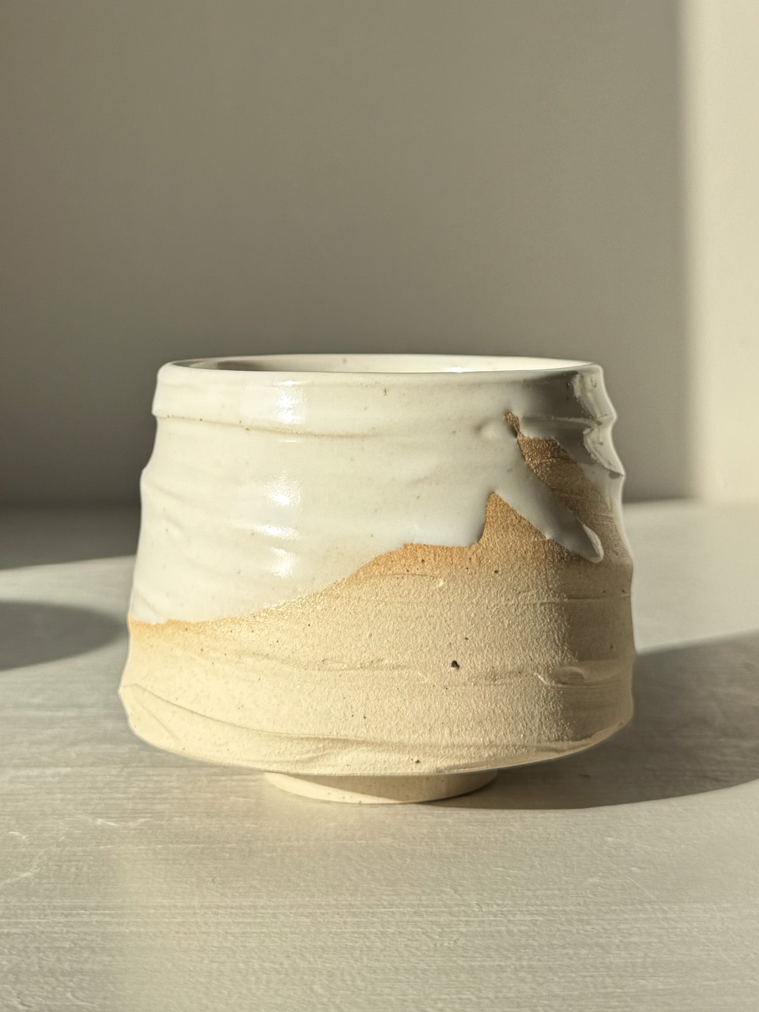 Handcrafted Yunomi Cup – Glossy White #01 with soft curves and flowing glaze, perfect for tea or coffee. Made from warm stoneware.