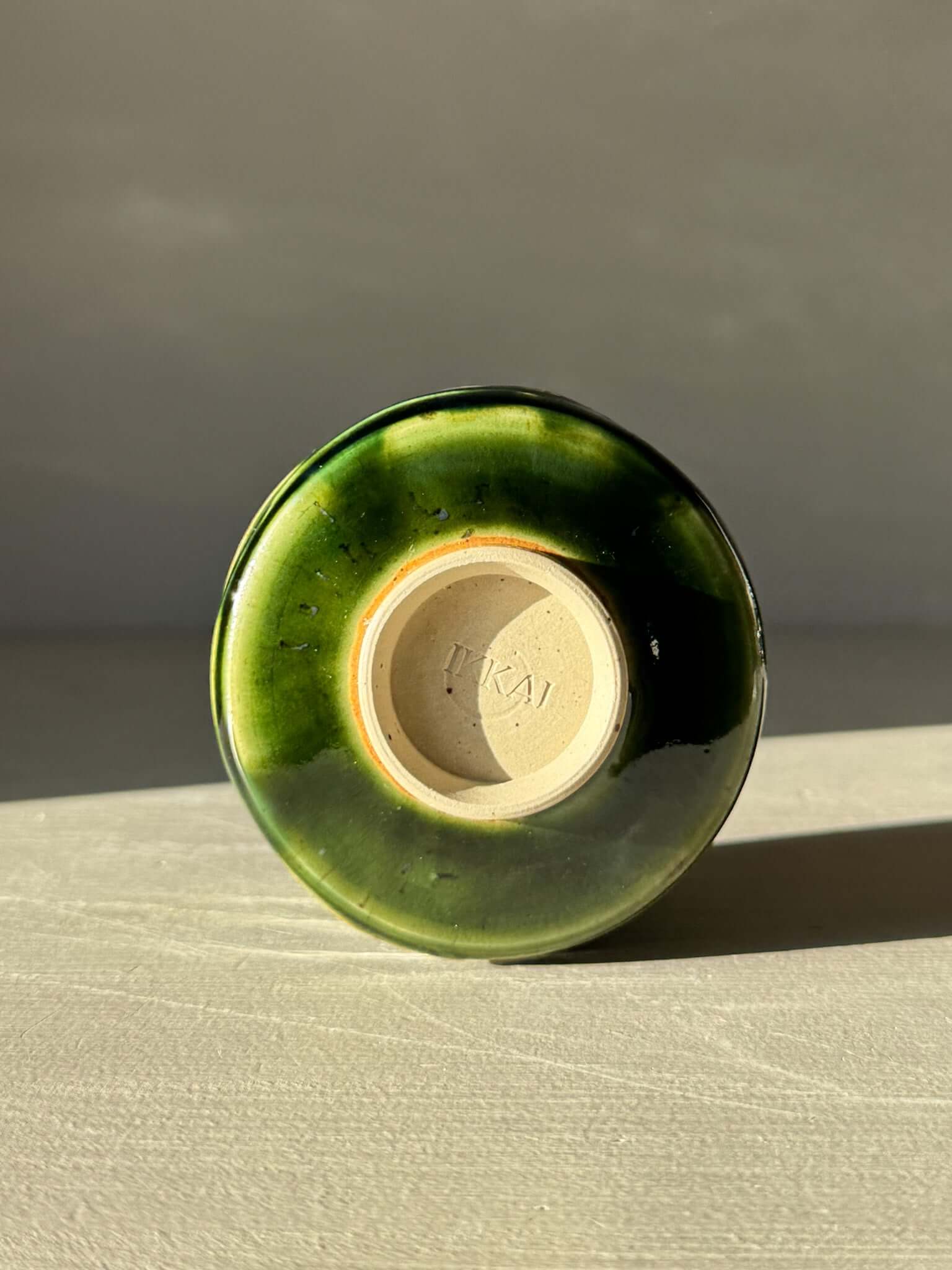 Base view of Yunomi Cup - Hinoki #10 with deep green glaze and subtle texture from handmade slip decoration.