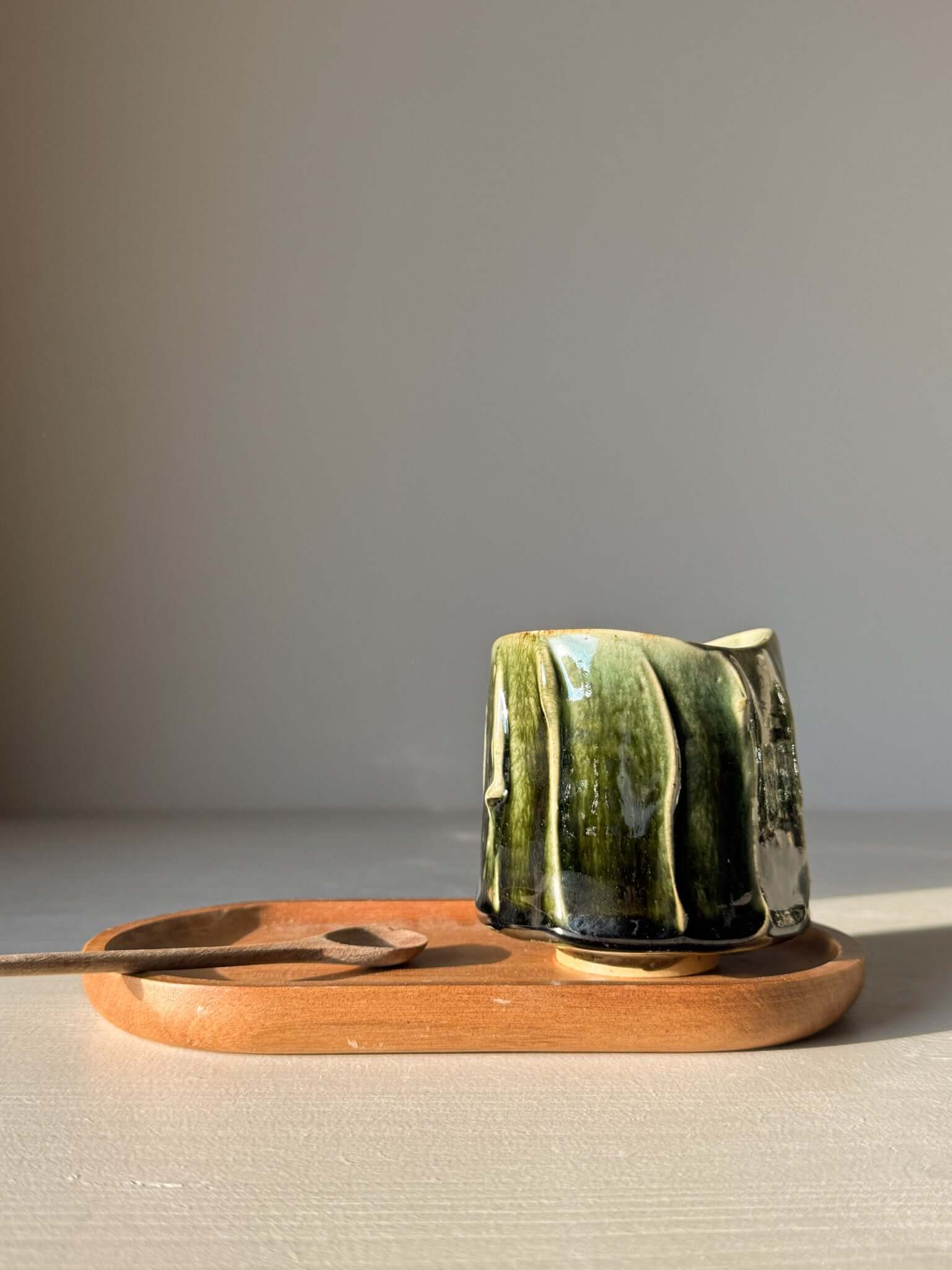 Yunomi Cup - Hinoki #13 with deep green glaze and handmade texture on a wooden tray