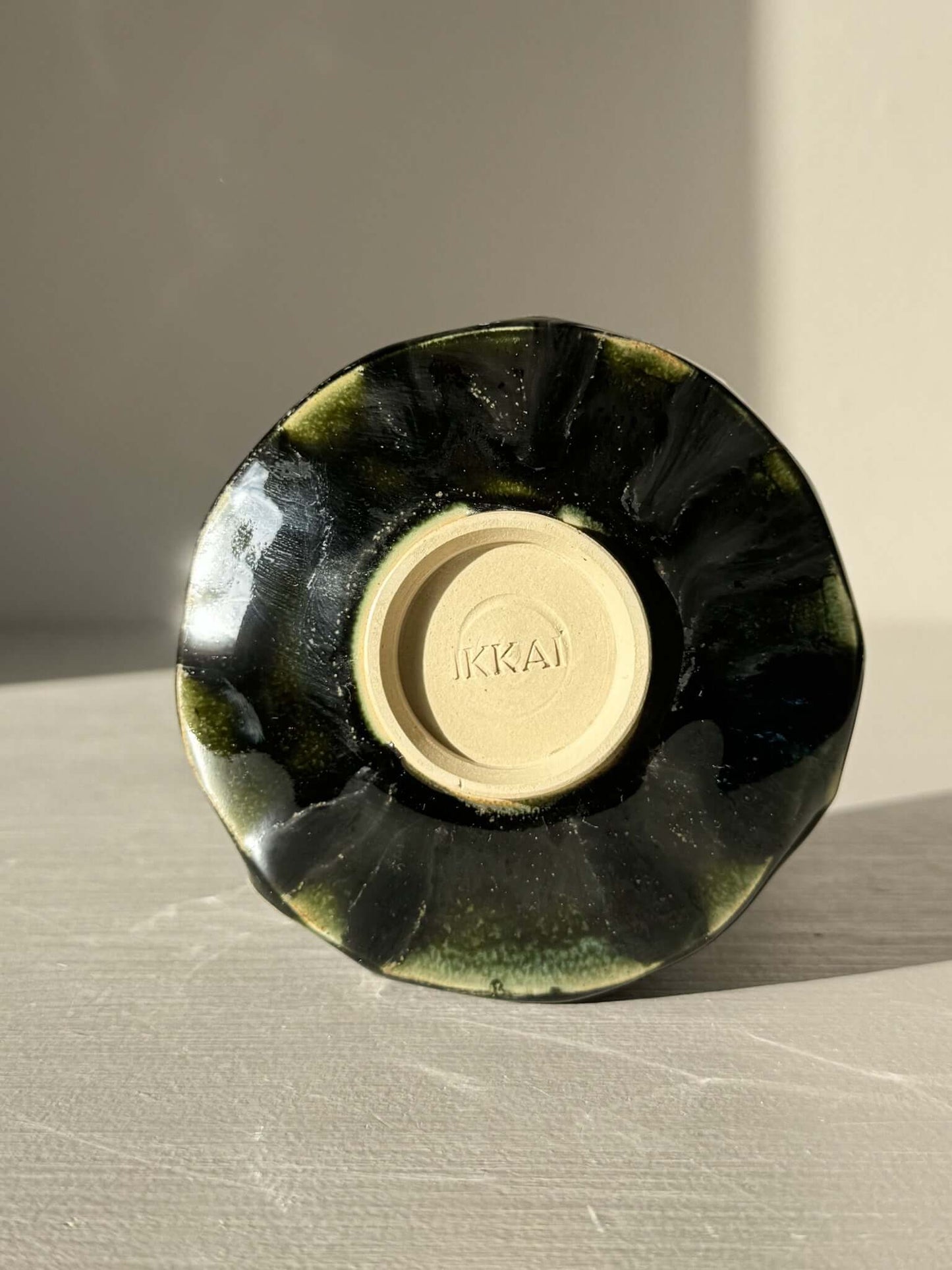 Yunomi Cup - Hinoki #27 displayed upside down showing unique deep green glaze with subtle texture on ceramic surface.