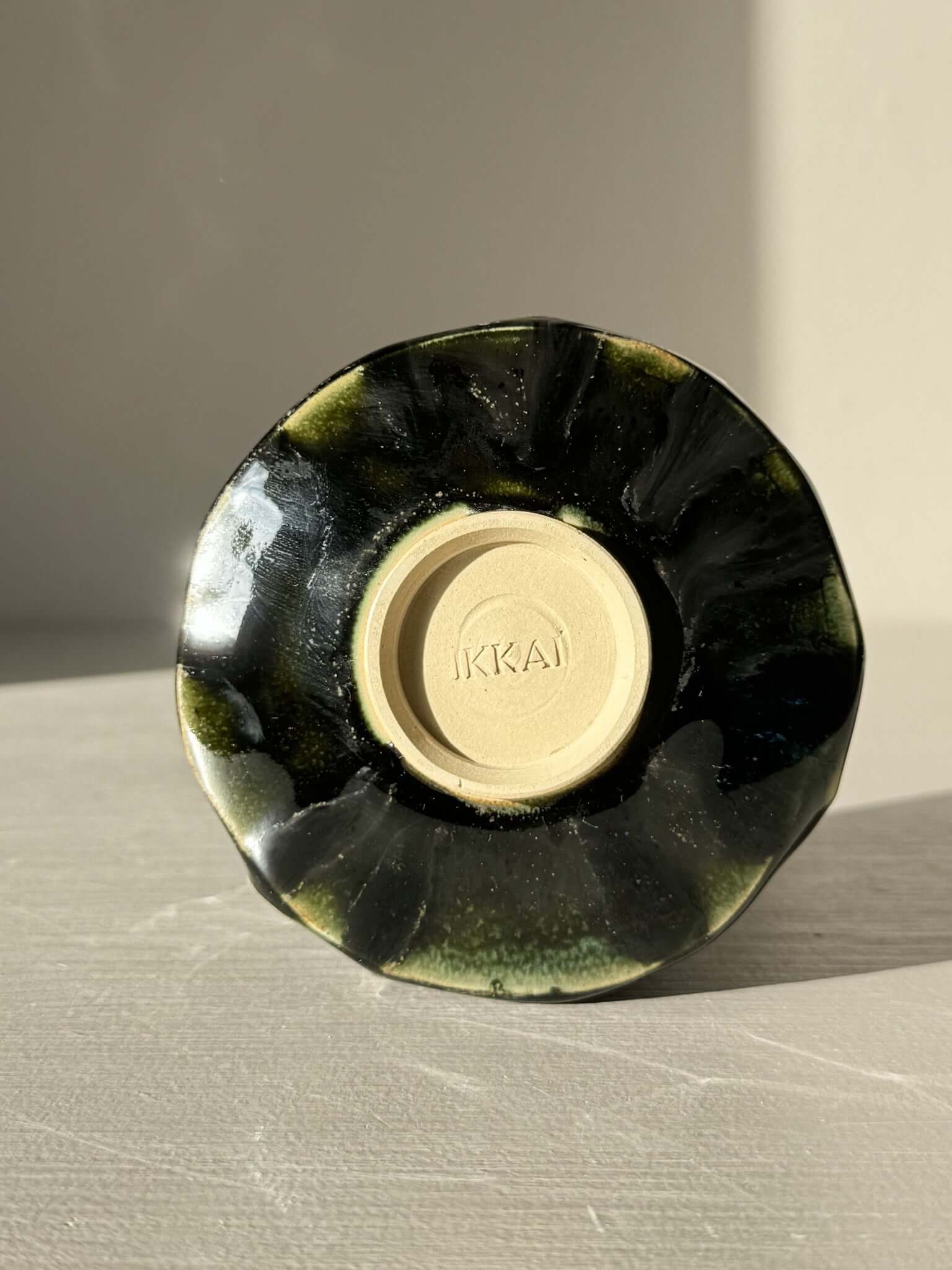 Yunomi Cup - Hinoki #27 displayed upside down showing unique deep green glaze with subtle texture on ceramic surface.