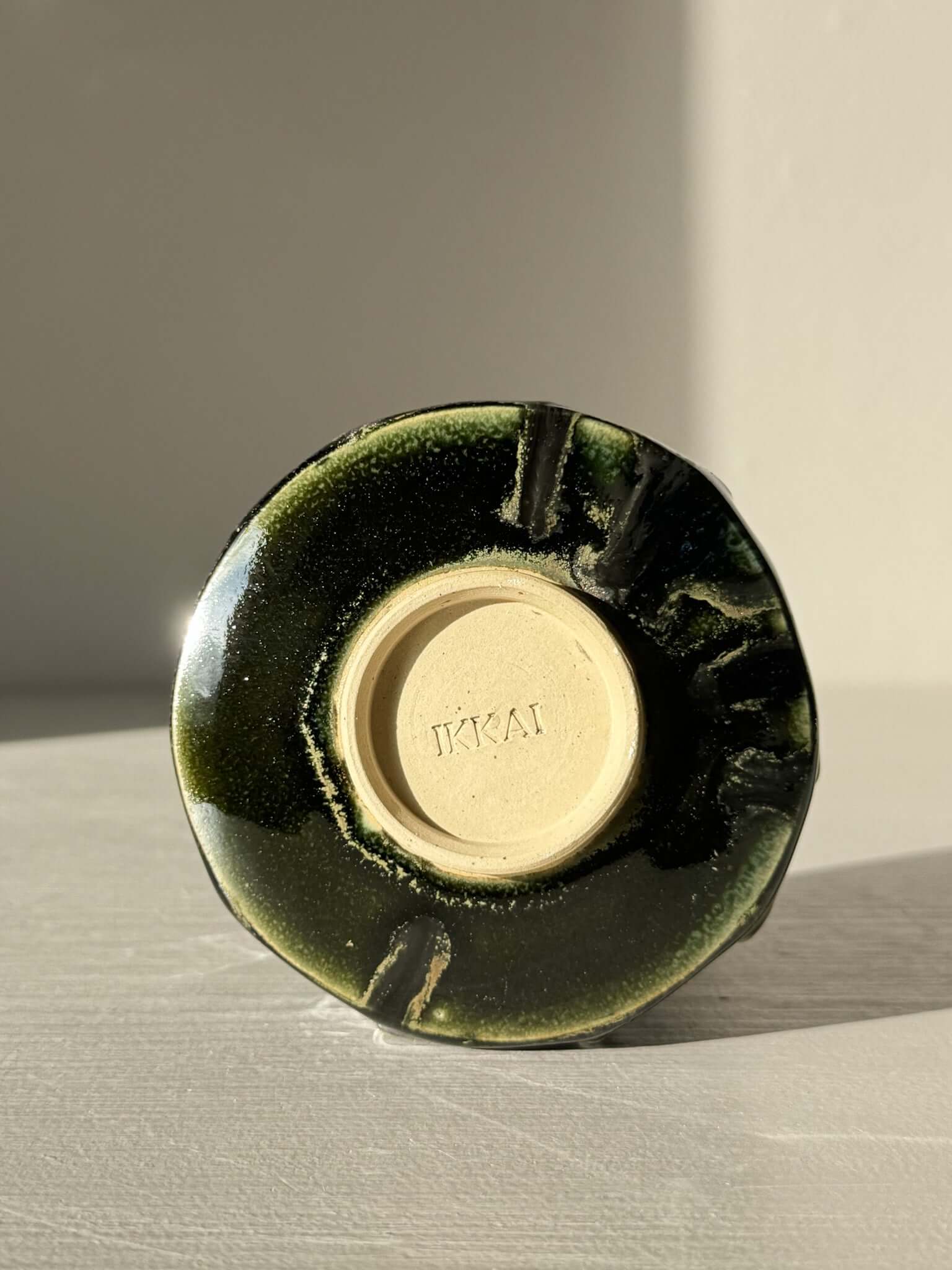 Bottom view of Yunomi Cup - Hinoki #29, showing handmade slip design and deep green glaze.