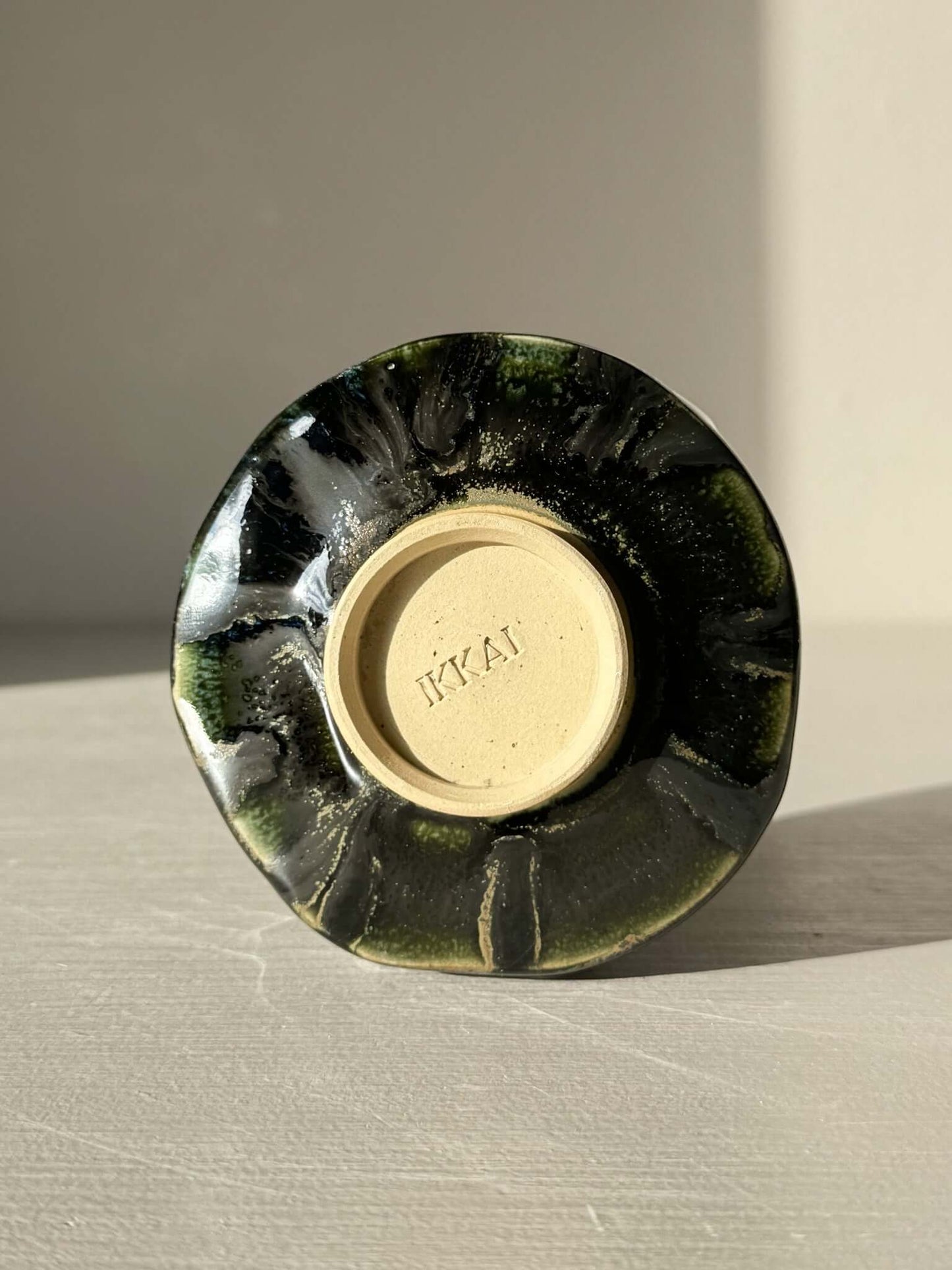 Bottom view of Yunomi Cup - Hinoki #30 showing unique slip design with deep green glaze settling into textured lines.