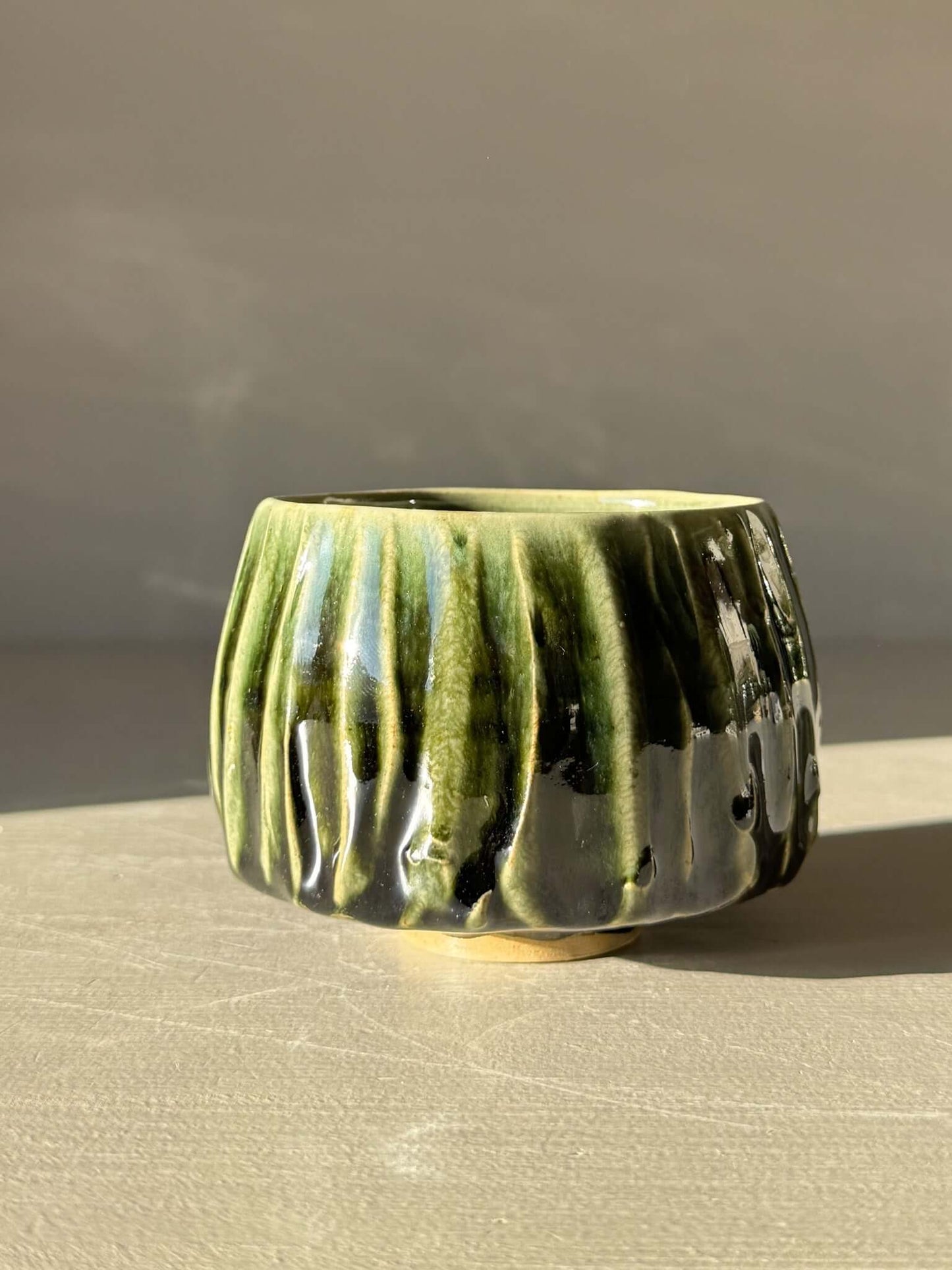 Yunomi Cup - Hinoki #12 with deep green glaze, handmade with flowing slip lines, showcasing variation and texture.