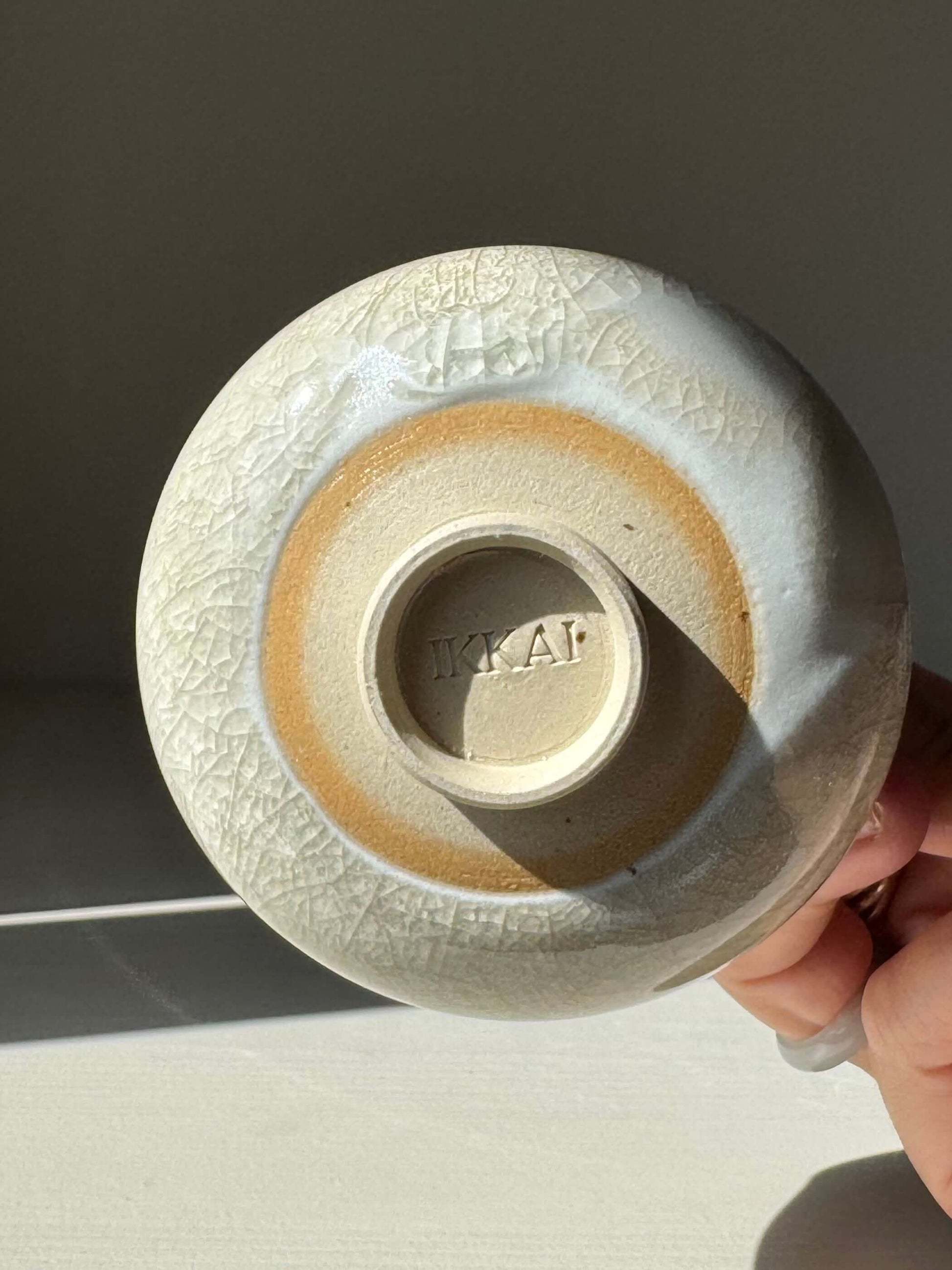 Bottom view of Yunomi Cup - Kannyū Series #06, handmade ceramic with crackle glaze and softly flowing rim.