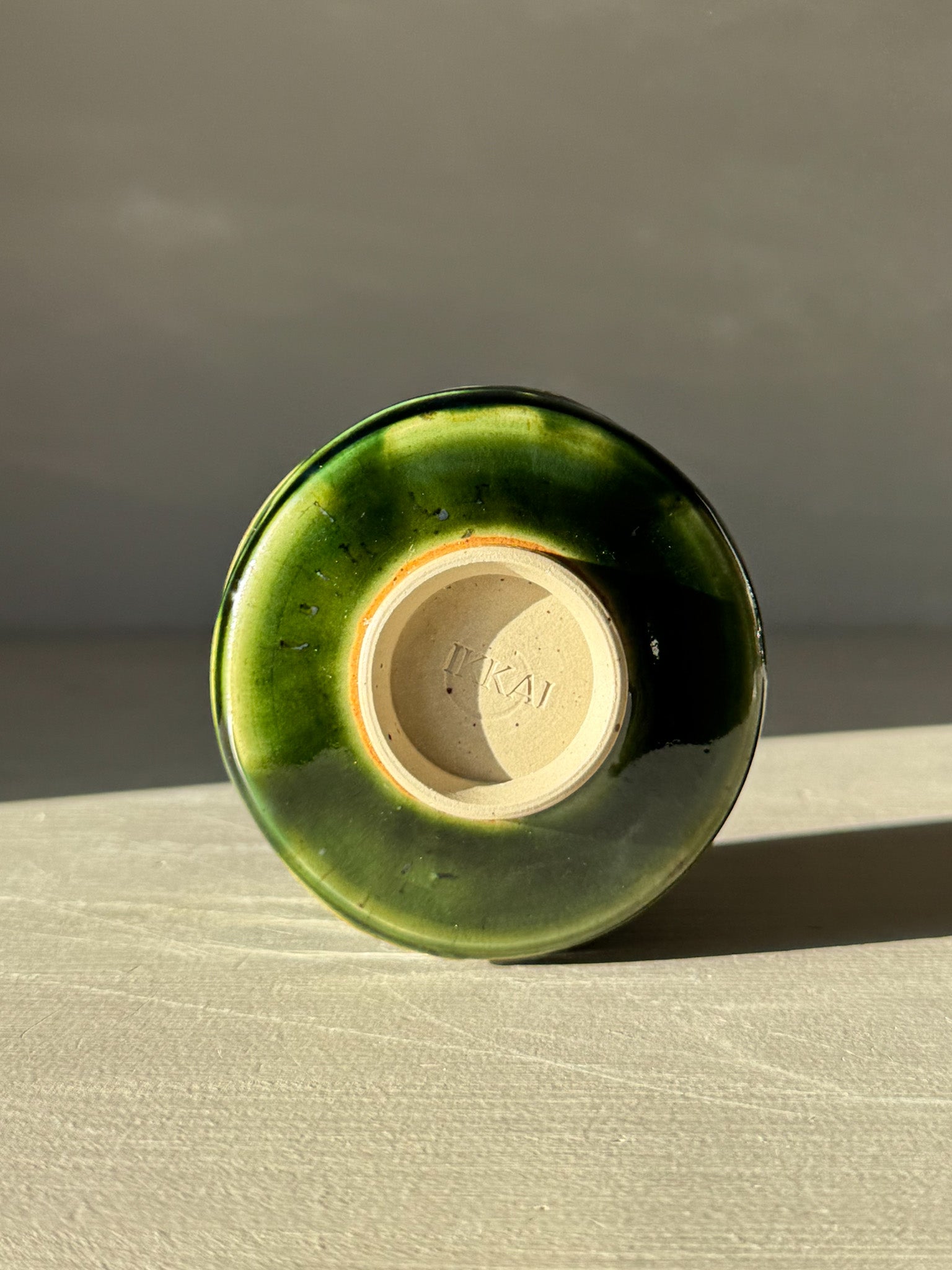 Base view of Yunomi Cup - Hinoki #10 with deep green glaze and subtle texture from handmade slip decoration.
